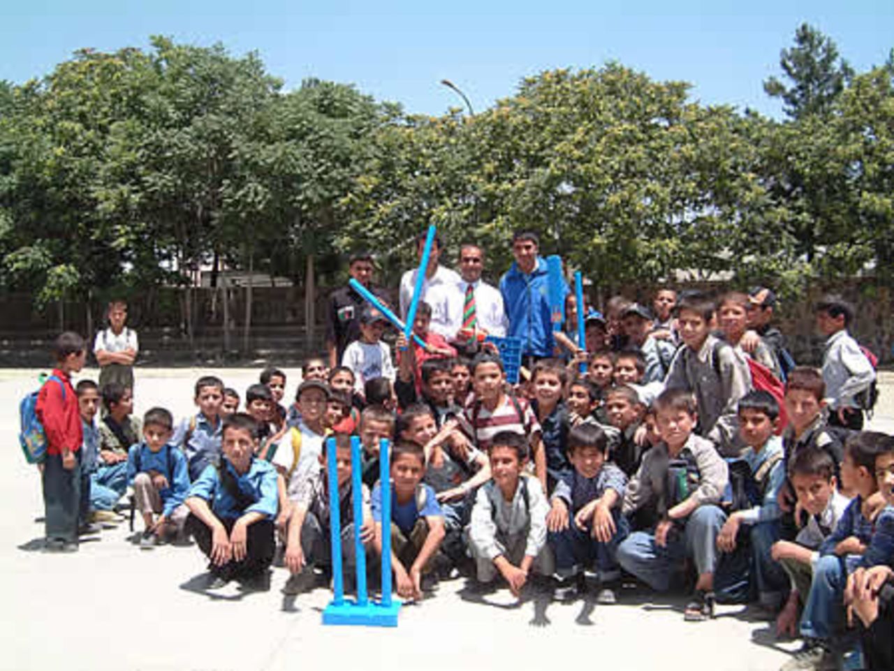 Isteqlal High School children and staff with Taj Malik Afghan National coach (white shirt and tie), ACF GM Abdul Khalil (black shirt) and Khalik Dad Noori (blue shirt) receiving Kwik cricket set donated by ECB.