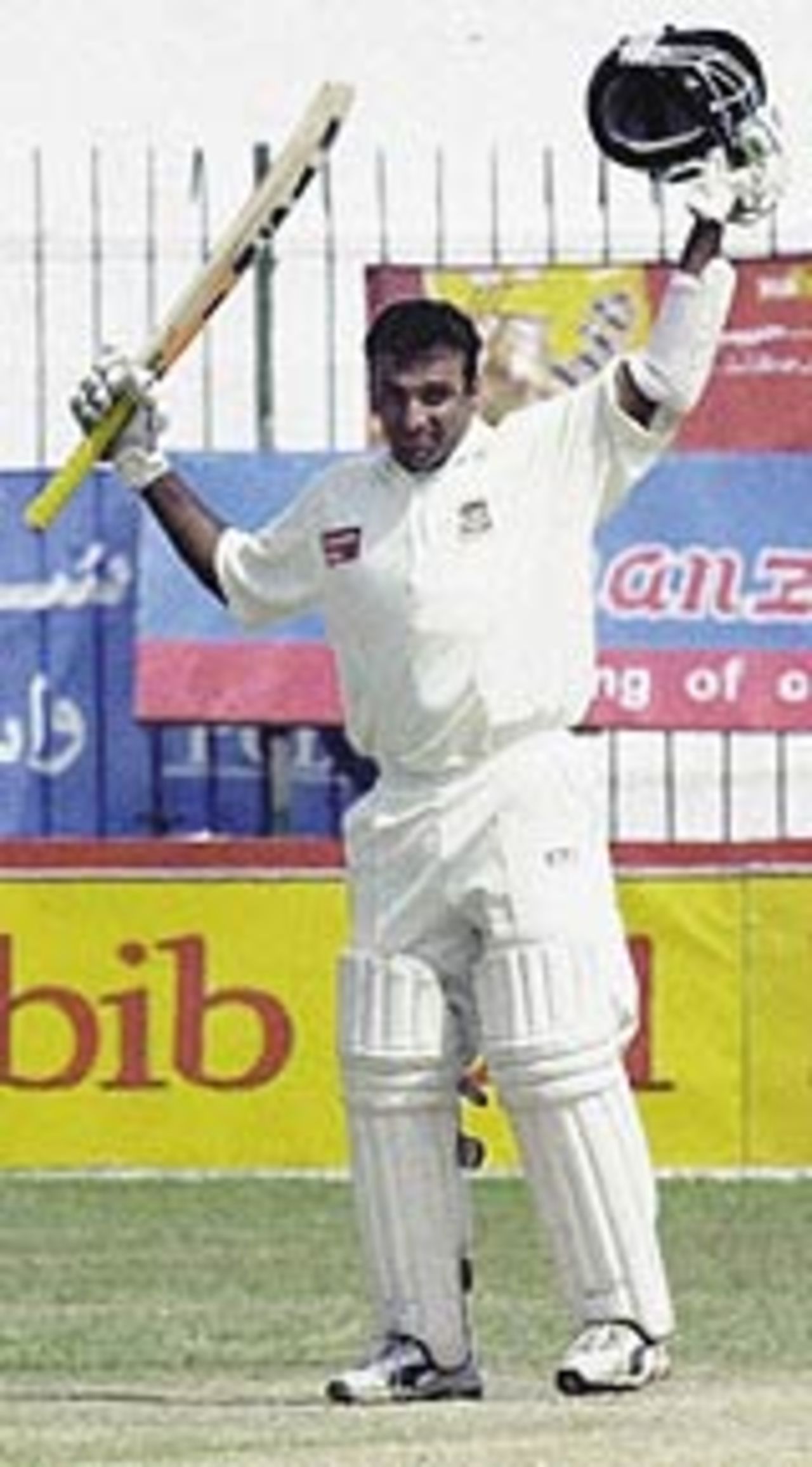Javed Omar raises his bat in celebration of his maiden century, Pakistan v Bangladesh, 2nd Test, Peshawar, 2nd day, August 28, 2003