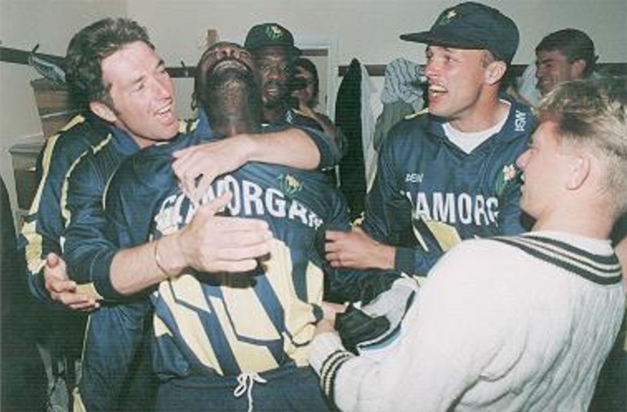 An emotional Viv Richards celebrates Glamorgan's Sunday League success. Matthew Maynard is hugging the emotional West Indian, with Roland Lefebvre to the right in a cap, and Stuart Phelps in the foreground. Steve Bastien and Steve Watkin are in the background.