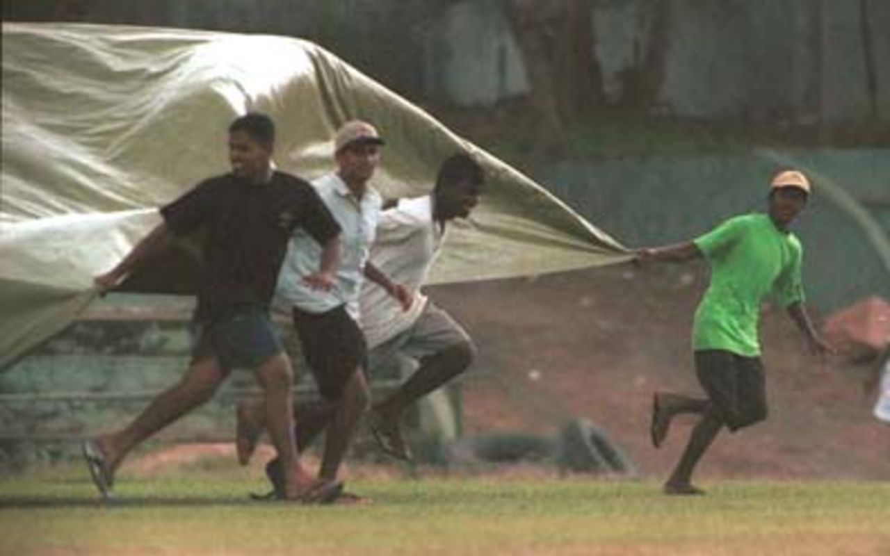 Ground staff collect water from the covers during the third day of the third cricket Test between Sri Lanka and Pakistan in Asgiriya International cricket stadium in Kandy, Sri Lanka on Friday, June. 30, 2000