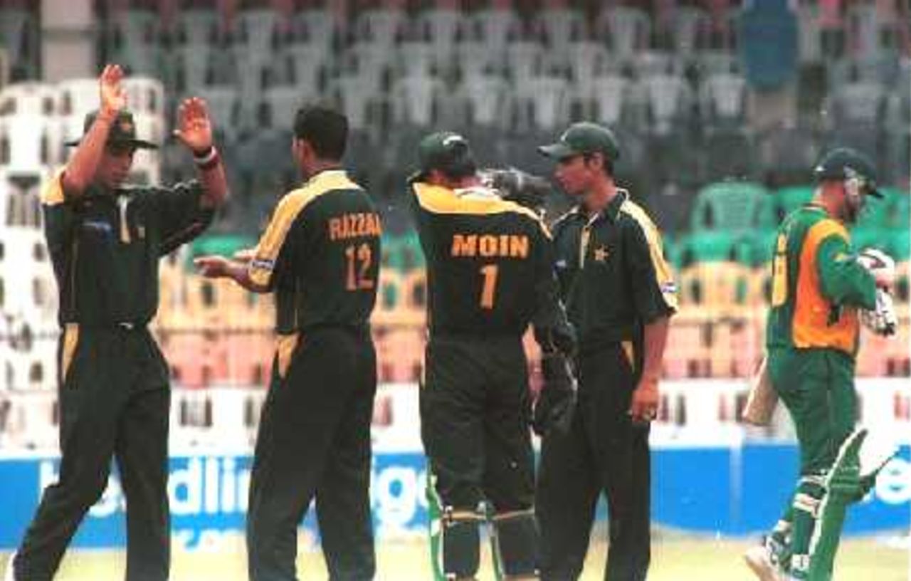 South African batsman Andrew Hall walks back to the pavilion as Pakistani teammates celebrates during the Singer Cup Triangular day and night limited overs cricket match between South Africa and Pakistan at Premadasa International cricket stadium in Colombo, Sri Lanka on Saturday, July. 8, 2000.Hall made 27 runs; South Africa scored 241 runs in allocated 50 overs
