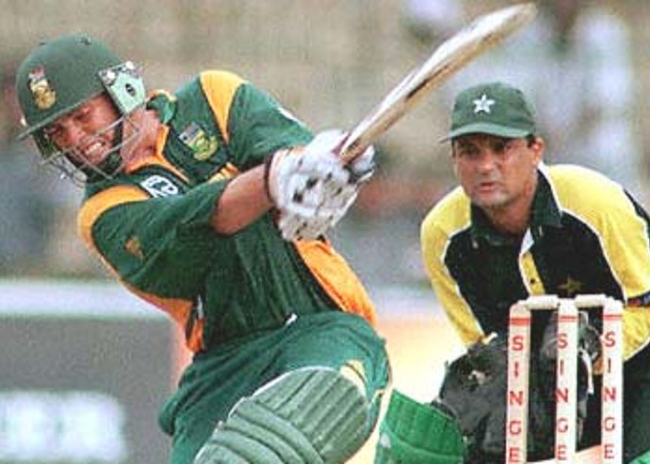 South African top scorer Jacques Kallis hits a six on his way to a score of 83 in the day-night limited overs match against Pakistan in the Singer Cup triangular. Pakistan skipper Moin Khan looks on. Pakistan have been set a target of 242 to win. Singer Triangular Series, 2000, 3rd Match, Pakistan v South Africa, R.Premadasa Stadium, Khettarama, Colombo, 8 July 2000.