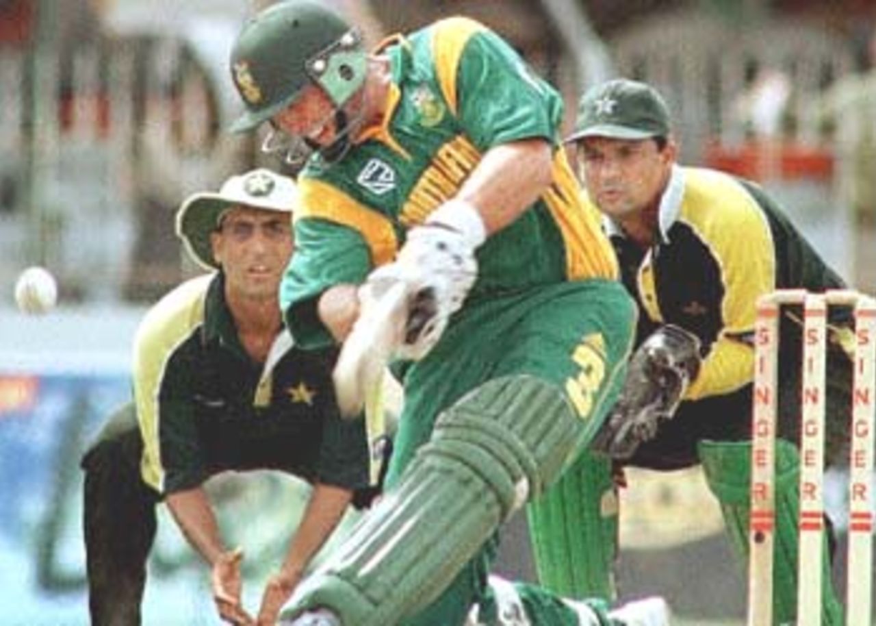 South African batsman Jacques Kallis (C) misses an attempted sweep in the match against Pakistan in the Singer Triangular series in the Sri Lankan capital of Colombo as Pakistani captain and wicketkeeper Moin Khan (R) looks on. Kallis finished out for 27 as South Africa won the match by seven wickets to head to the finals against host Sri Lanka. Player at L is unidentified. Singer Triangular Series, 2000/01, 6th Match, Pakistan v South Africa, Sinhalese Sports Club Ground, Colombo, 12 July 2000.