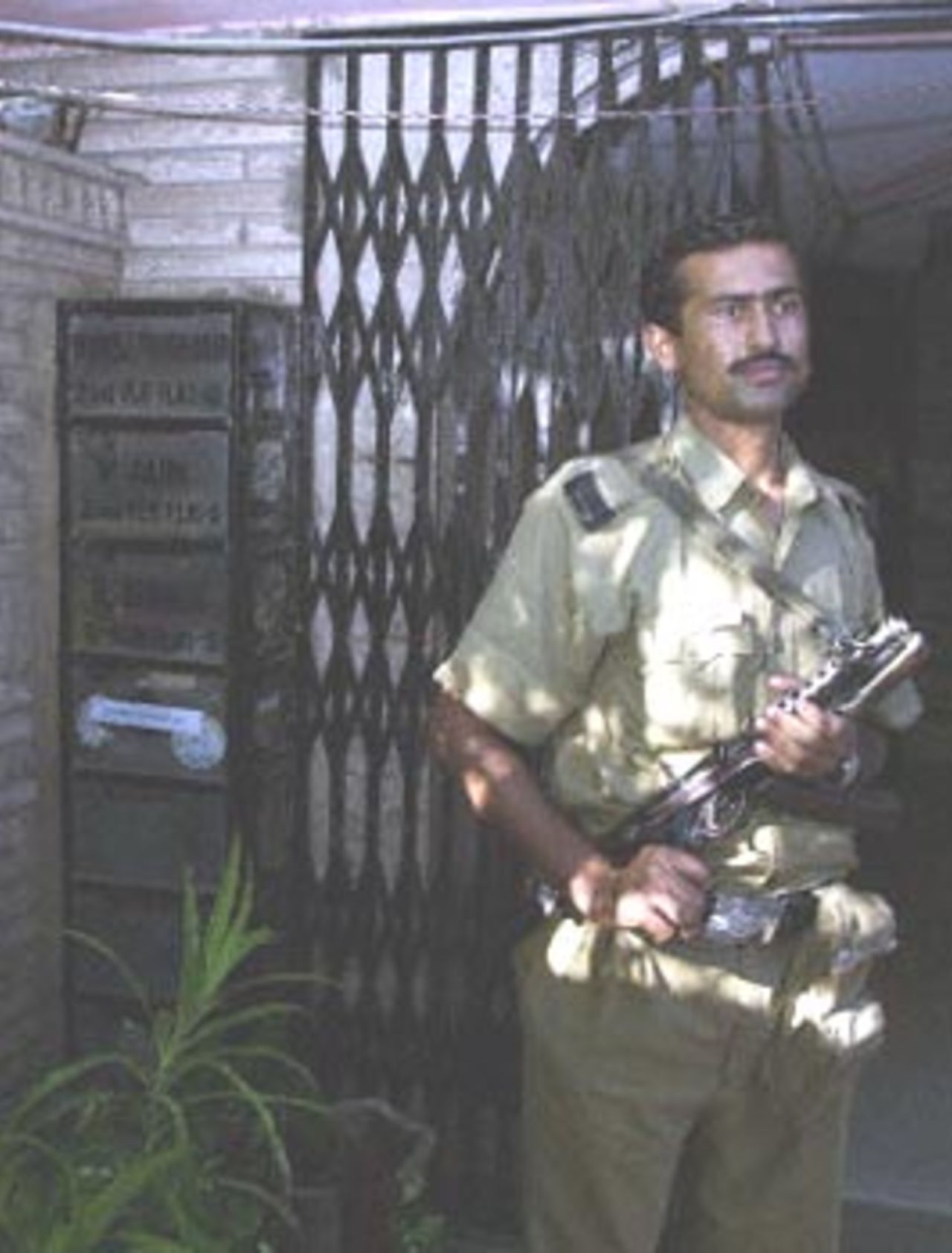 A Delhi police officer stands guard in front of the flat of former cricketer Manoj Prabhakar during a raid by income tax officials. Income tax officials have raided the homes of top Indian cricket players around the country, threatening a fresh scandal in a sport already laid low by match-fixing charges.