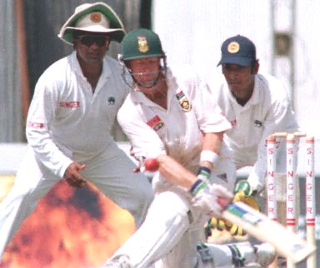 Rhodes attemps the sweep as Ranatunga and Sangakkara look on. South Africa in Sri Lanka 2000/01, 1st Test, Sri Lanka v South Africa Galle International Stadium, 20-24 July 2000. (Day 3)