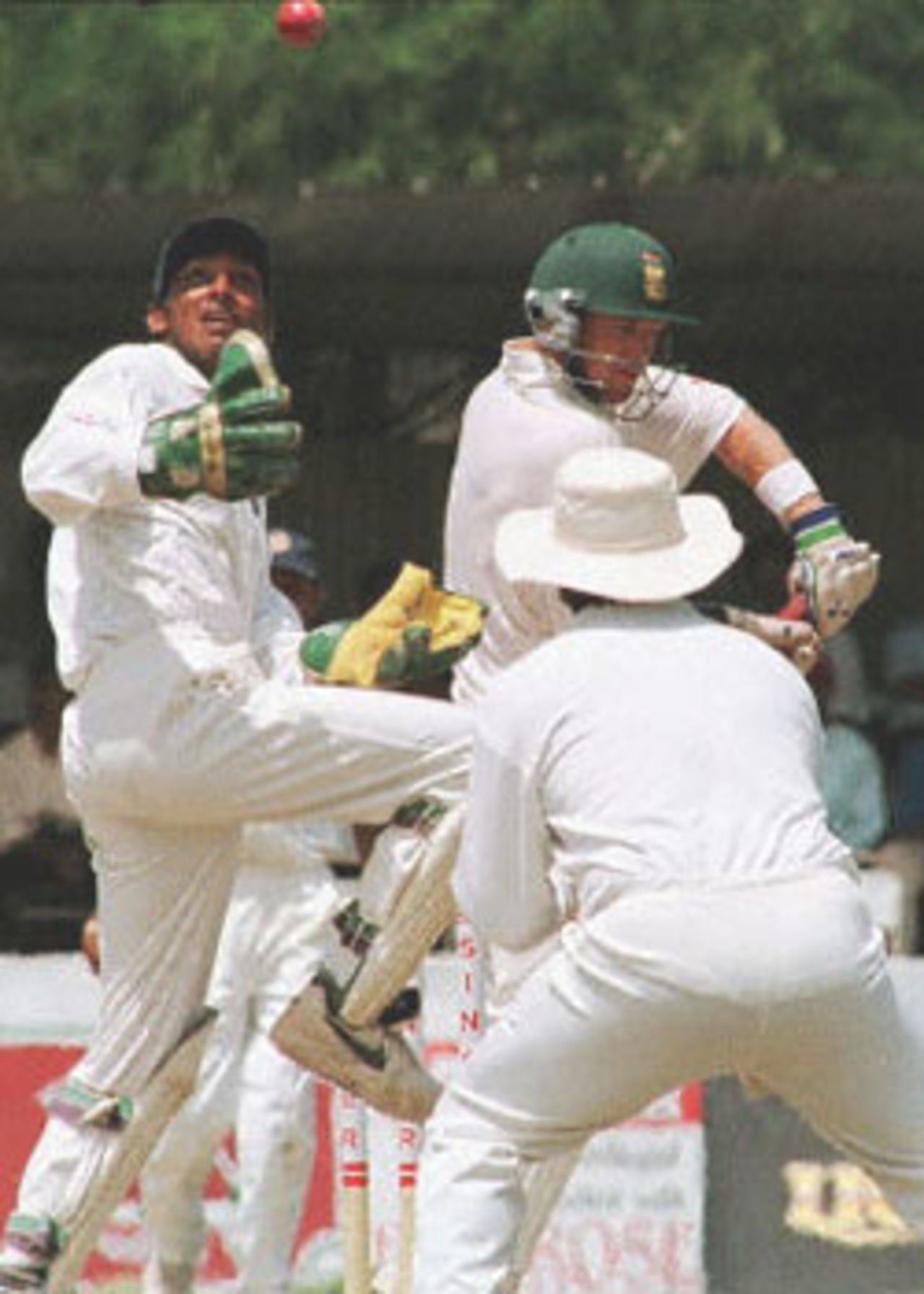 Sri Lankan wicket keeper Kumar Sangakkara (L) attempts to hold the ball as South African batsman Jonty Rodes (R) looks on during the fourth day of the first cricket test between South Africa and Sri Lanka. Sri Lanka won the match by an innings and 15 runs to take a 1-0 lead in the three match series. South Africa in Sri Lanka, 2000/01, 1st Test, Sri Lanka v South Africa, Galle International Stadium, 20-24 July 2000 (Day 4).