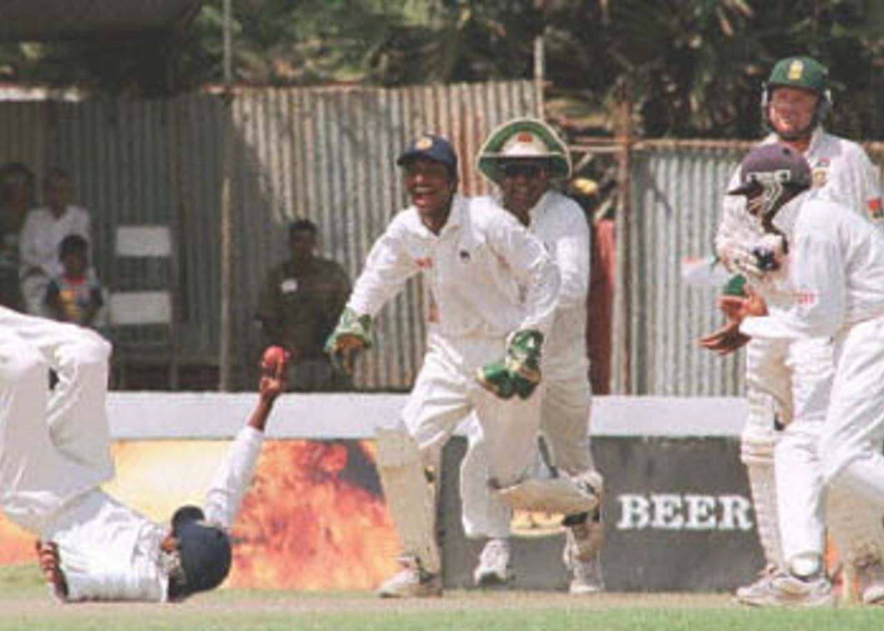 Sri Lankan fielder Russel Arnold (L) holds the ball after a catch to dismiss South African batsman Daryll Cullinan (R, rear) as wicket keeper Kumar Sangakarra (C), Arjuna Ranatunga (3rd L) and Mahela Jayawardena (R) celebrate during the forth day of the first cricket test against South Africa. Sri Lanka won the match by an innings and 15 runs to take a 1-0 lead in the three match series. South Africa in Sri Lanka, 2000/01, 1st Test, Sri Lanka v South Africa, Galle International Stadium, 20-24 July 2000 (Day 4).