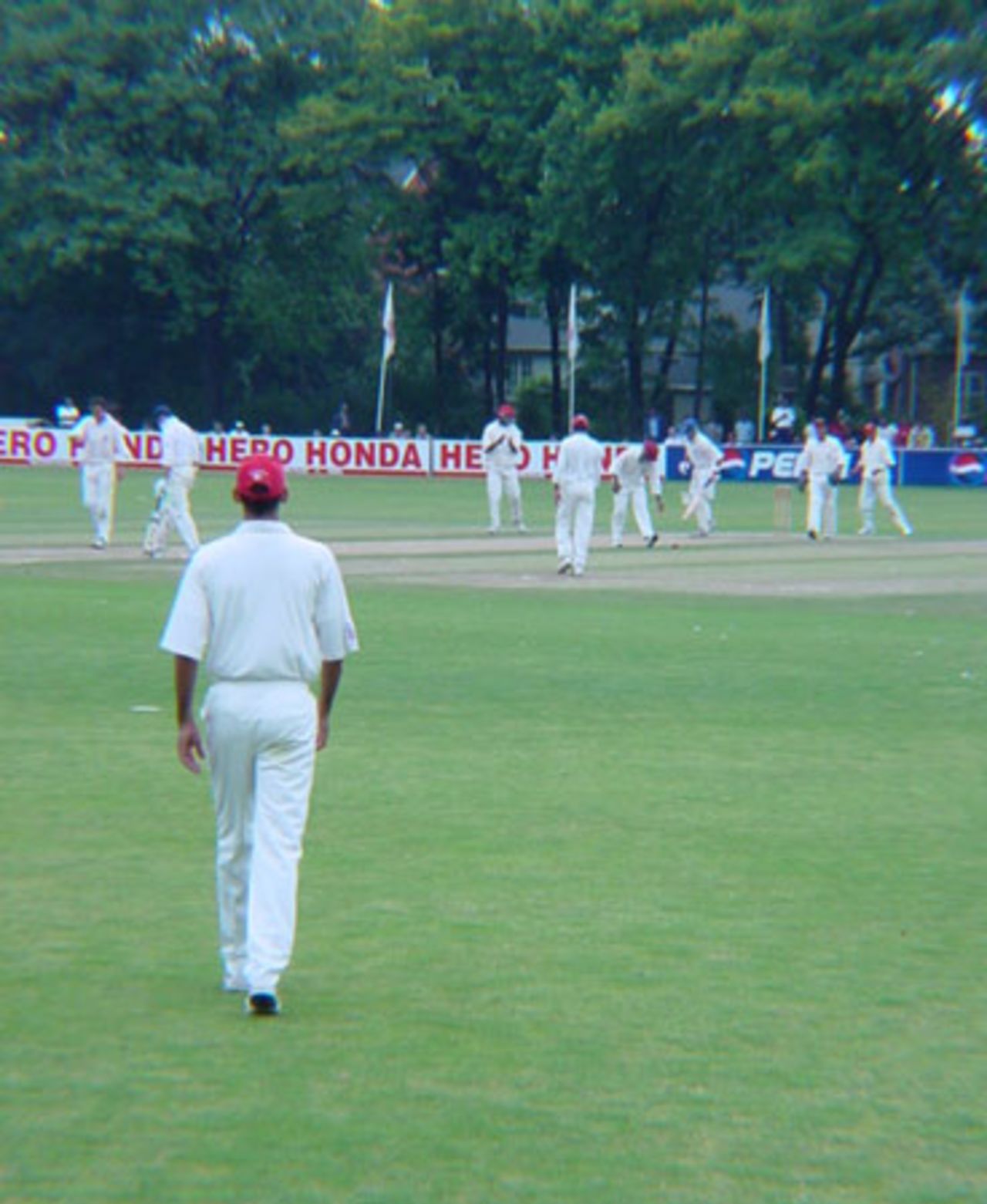 Canadian left arm orthodox spinner Barry Seebaran walks in to field from long off as off spinner John Davison bowls to Scottish batsman Drew Parsons. ICC Trophy 2001: Canada v Scotland, Toronto Cricket, Skating and Curling Club, 17 July 2001.