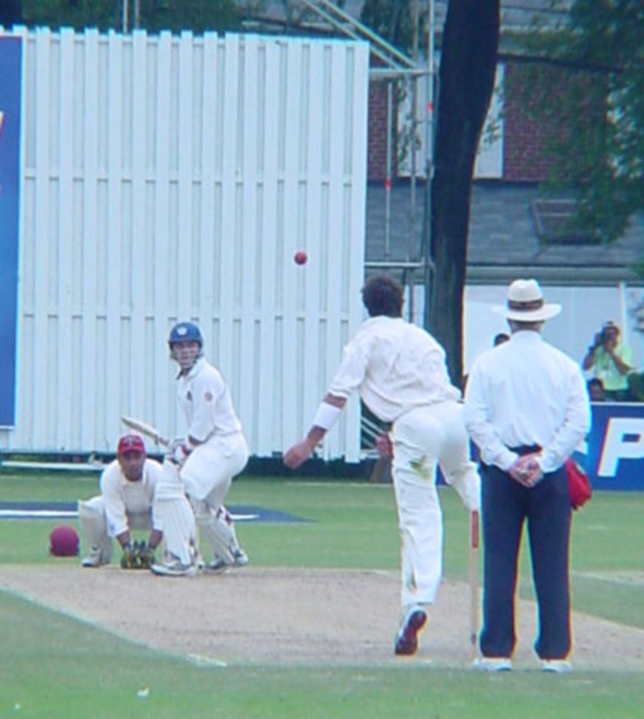 Canadian off spinner John Davison flights up a delivery to Scottish batsman George Salmond. Wicket-keeper Ashish Bagai and South African umpire Rudi Koertzen look on. ICC Trophy 2001: Canada v Scotland, Toronto Cricket, Skating and Curling Club, 17 July 2001.