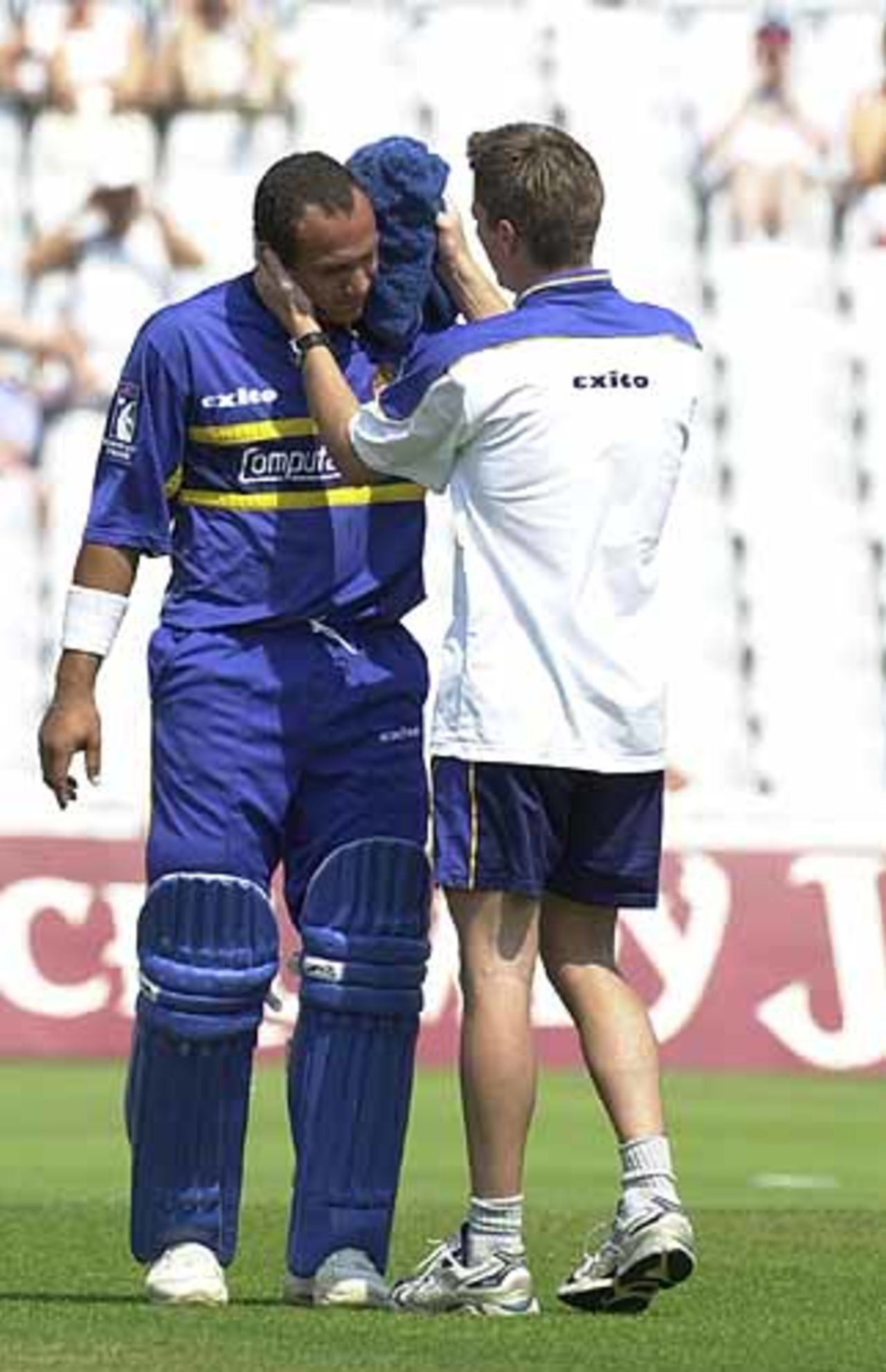 Mark Butcher is attended to by the Surrey physio after being struck by Neil Carter, Norwich Union League , 29th July 2001, Birmingham