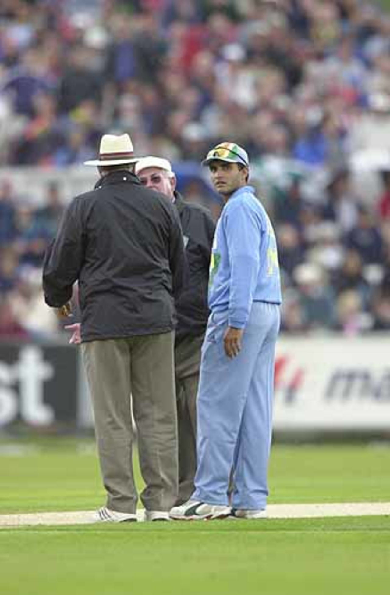The umpires in earnest discussion concerning the weather as Ganguly waits on, England v India at Chester-le-Street, July 2002