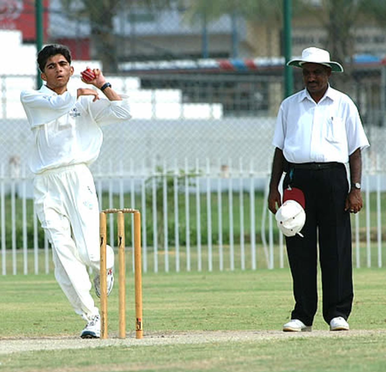Abdul Aziz of Qatar bowls as the umpire looks on, Qatar Under-19s v United Arab Emirates Under-19s at United Bank Ltd Sports Complex Karachi, Youth Asia Cup 2003, 16 July 2003.