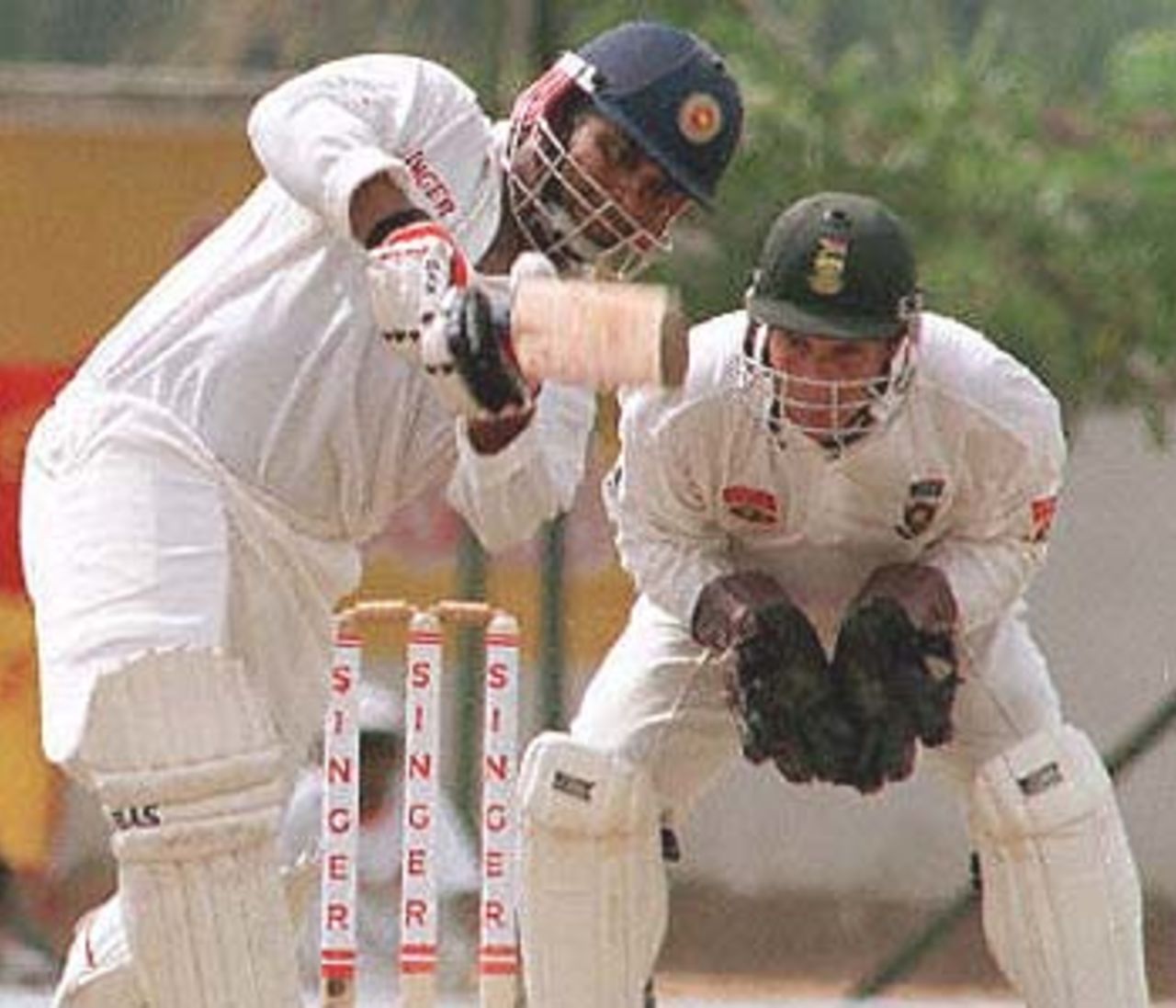 Sri Lankan batsman Arjuna Ranatunge sweeps the ball as wicket keeper Mark Boucher looks on during the fourth day of the second cricket test between South Africa and Sri Lanka. South Africa beat Sri Lanka by 7 runs to level the three match series 1-1. South Africa in Sri Lanka, 2000/01, 2nd Test, Sri Lanka v South Africa, Asgiriya Stadium, Kandy, 30July-03August 2000 (Day 4).