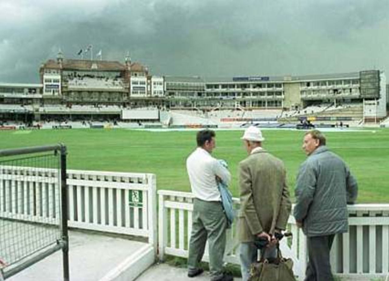 Spectators wait for a break in the rain at The Oval