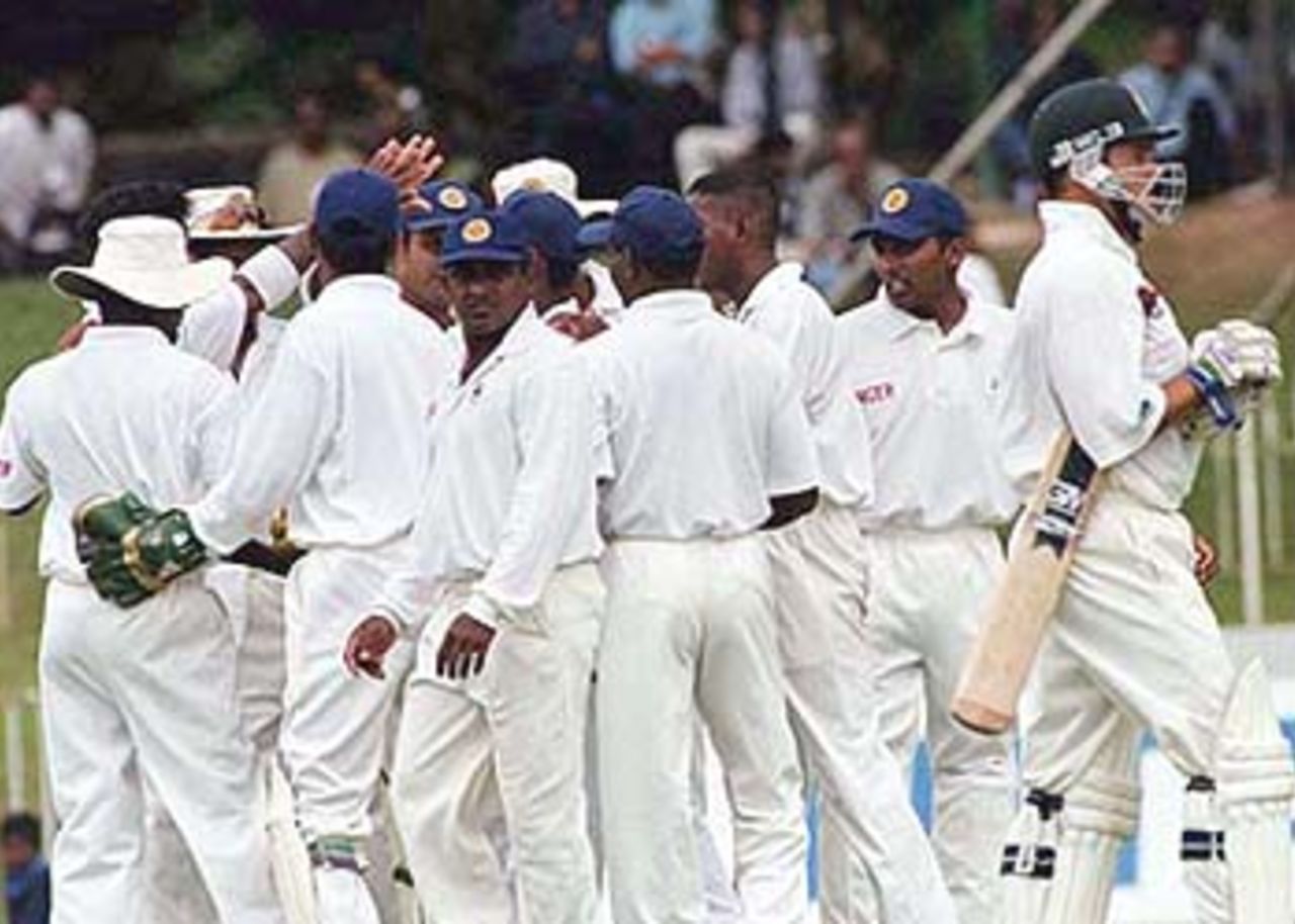 South African batsman Mark Boucher walks back as the Sri Lankan team celebrates, South Africa in Sri Lanka, 2000/01, 3rd Test, Sri Lanka v South Africa, Sinhalese Sports Club Ground, Colombo, 06-10 August 2000 (Day 1).