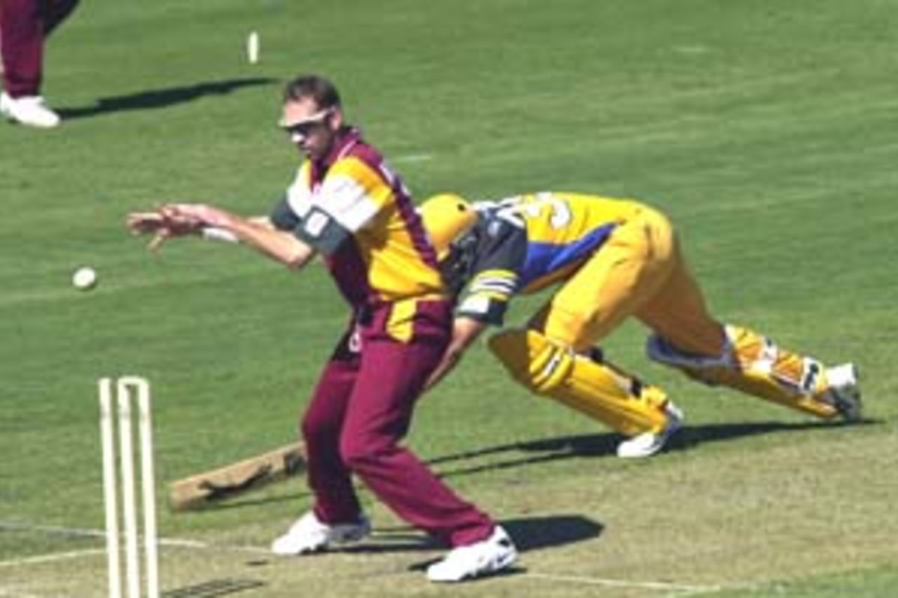 11 Aug 2000: Andrew Symonds of Australia is run out by Matthew Anderson of Queensland during the Australia versus Queensland practice match played at Allan Border Field in Brisbane, Australia. The Australian team are playing the practice match to prepare for the Super Challenge 2000 against South Africa.