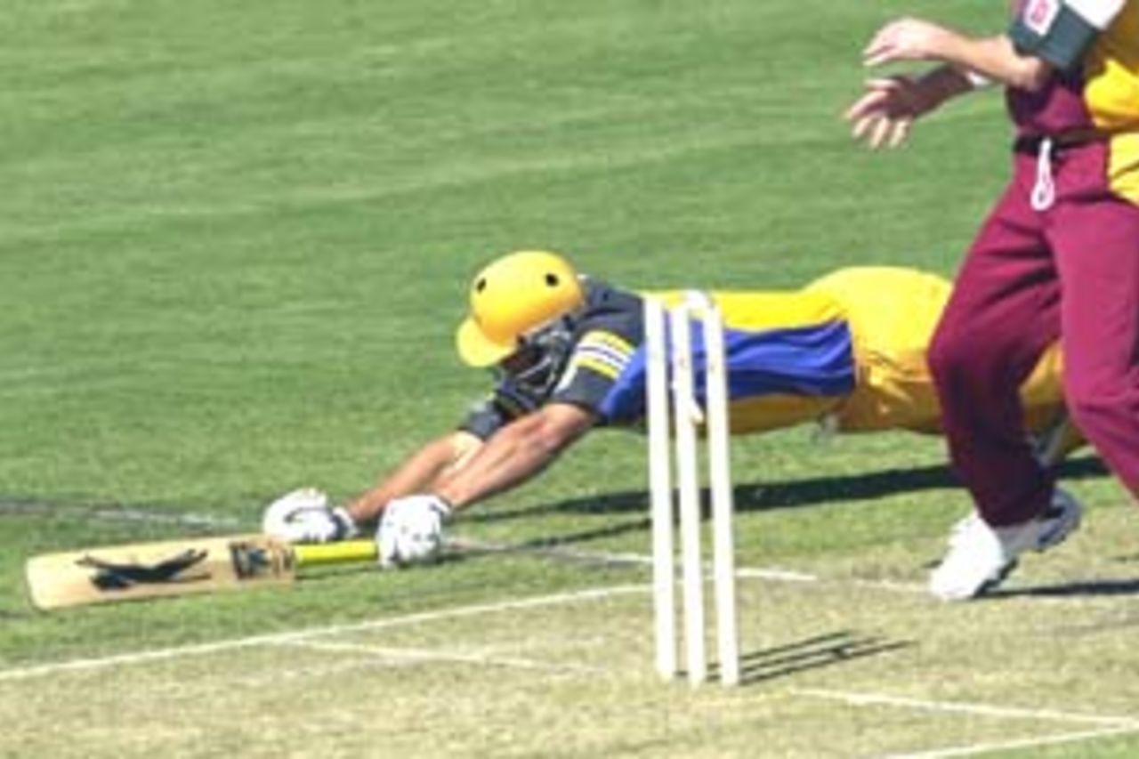 11 Aug 2000: Andrew Symonds of Australia is run out by Matthew Anderson of Queensland during the Australia versus Queensland practice match played at Allan Border Field in Brisbane, Australia. The Australian team are playing the practice match to prepare for the Super Challenge 2000 against South Africa.