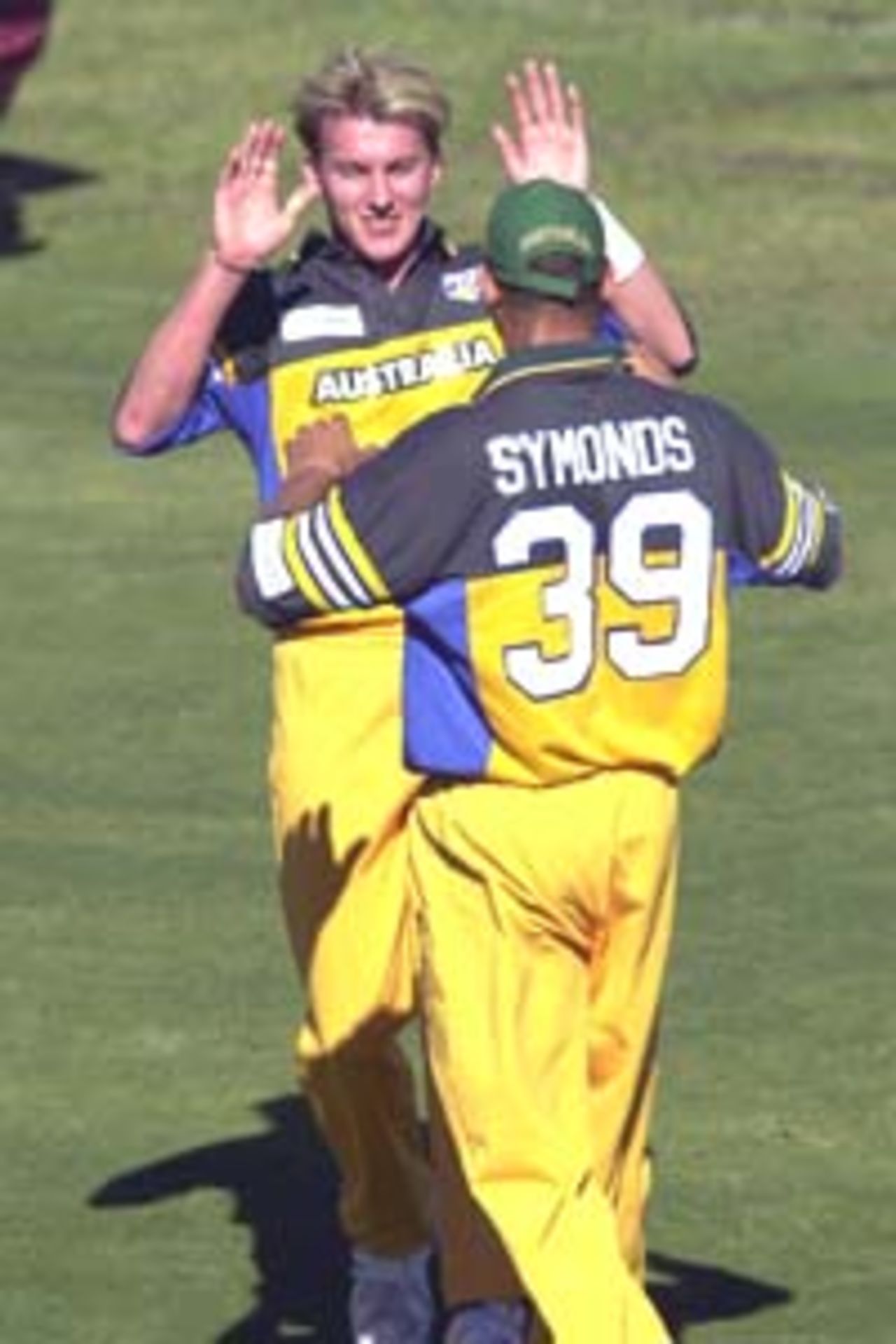 11 Aug 2000: Brett Lee of Australia celebrates getting the wicket of Jerry Cassell of Queensland with his team mate Andrew Symonds during the Australia versus Queensland practice match played at Allan Border Field in Brisbane, Australia. The Australian team are playing the practice match to prepare for the Super Challenge 2000 against South Africa.