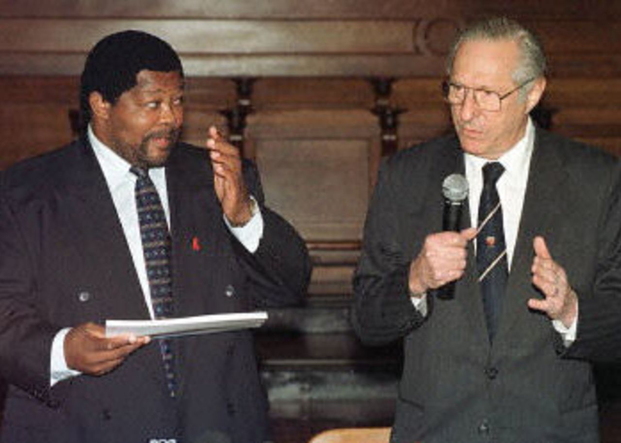 South African Sports minister Ngconde Balfour (L) receives 11 August 2000 an interim report on cricket corruption from Judge Edwin King during a press conference in Cape Town. The interim report summarizes evidence so far, but does not make recommendations on disgraced former cricket captain Hansie Cronje. The commission will resume its hearings in October 2000.