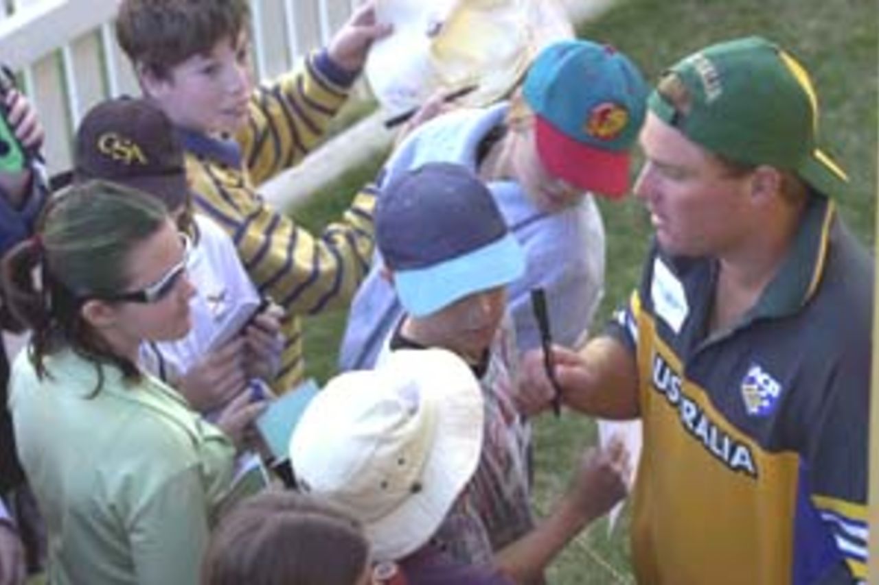 13 Aug 2000: Shane Warne of Australia signs autographs for fans during the game against Queensland at Allan Border Field in Brisbane, Australia. The Australian team are playing the practice game against Queensland in Brisbane to prepare for the Super Challenge 2000 against South Africa.