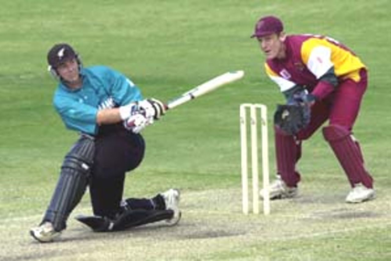 14 Aug 2000: Craig McMillan of New Zealand hits a four while Wade Seccombe of Queensland looks on during the New Zealand versus Queensland practice match at Allan Border Field in Brisbane, Australia. New Zealand scored 321 runs during their fifty overs.