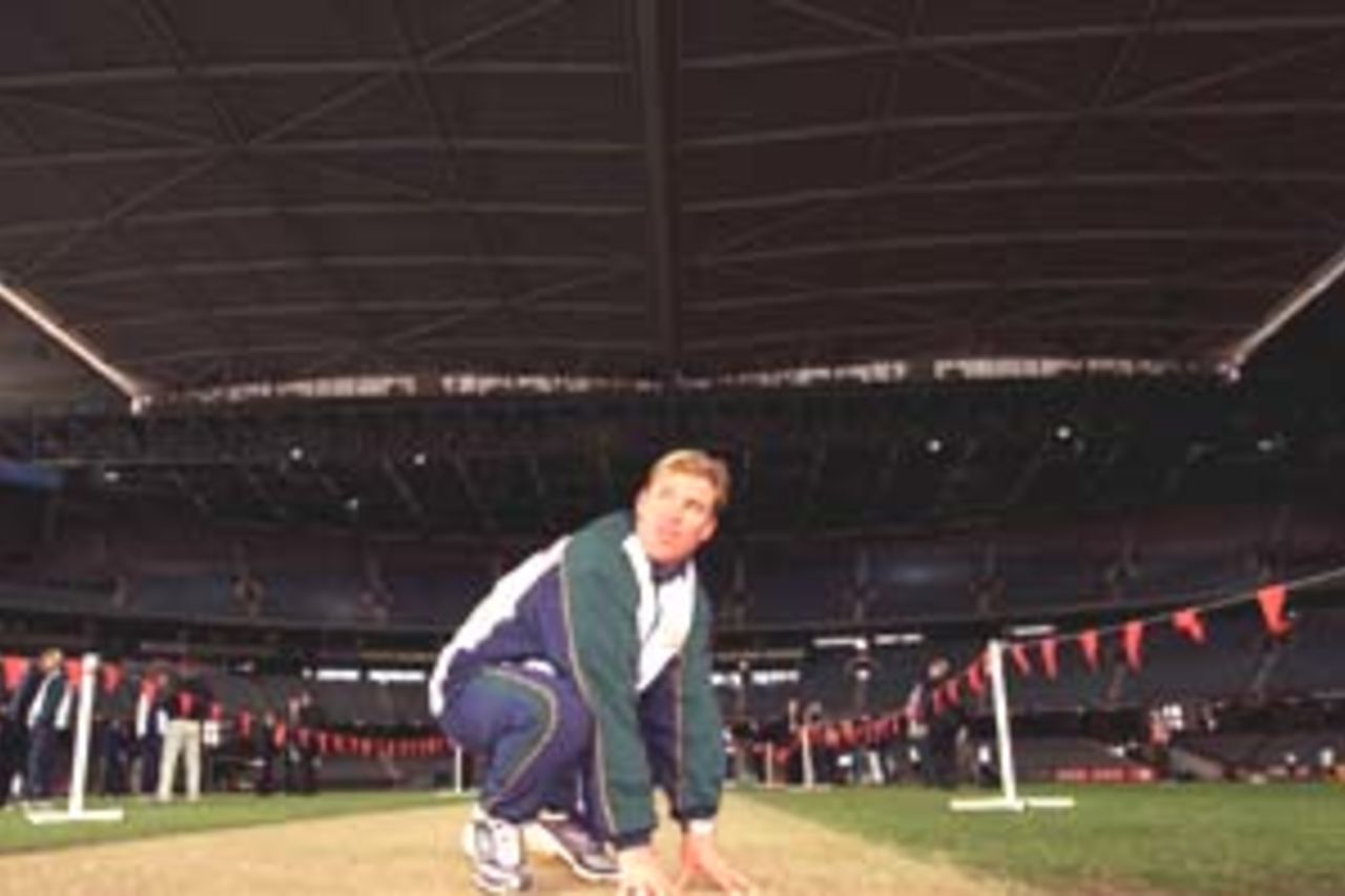 14 Aug 2000: Australian spinner Shane Warne inspects the pitch at Colonial Stadium, venue for the Super Challenge 2000 one day cricket series beginning Wednesday in Melbourne, Australia.