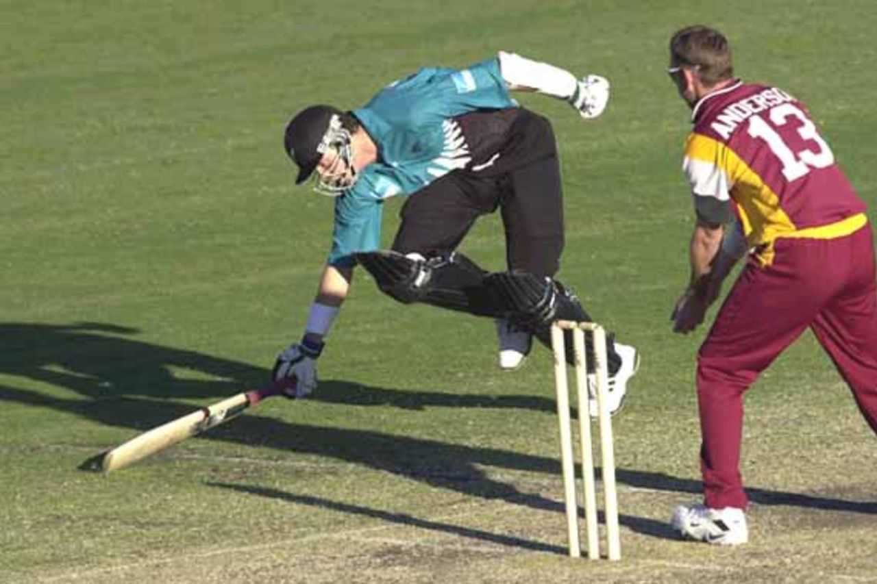 15 Aug 2000: Paul Wiseman of New Zealand just makes it back to his crease despite the efforts of Matthew Anderson of Queensland during the New Zealand versus Queensland practice match at Allan Border Field in Brisbane, Australia. Queensland won the game by 23 runs.