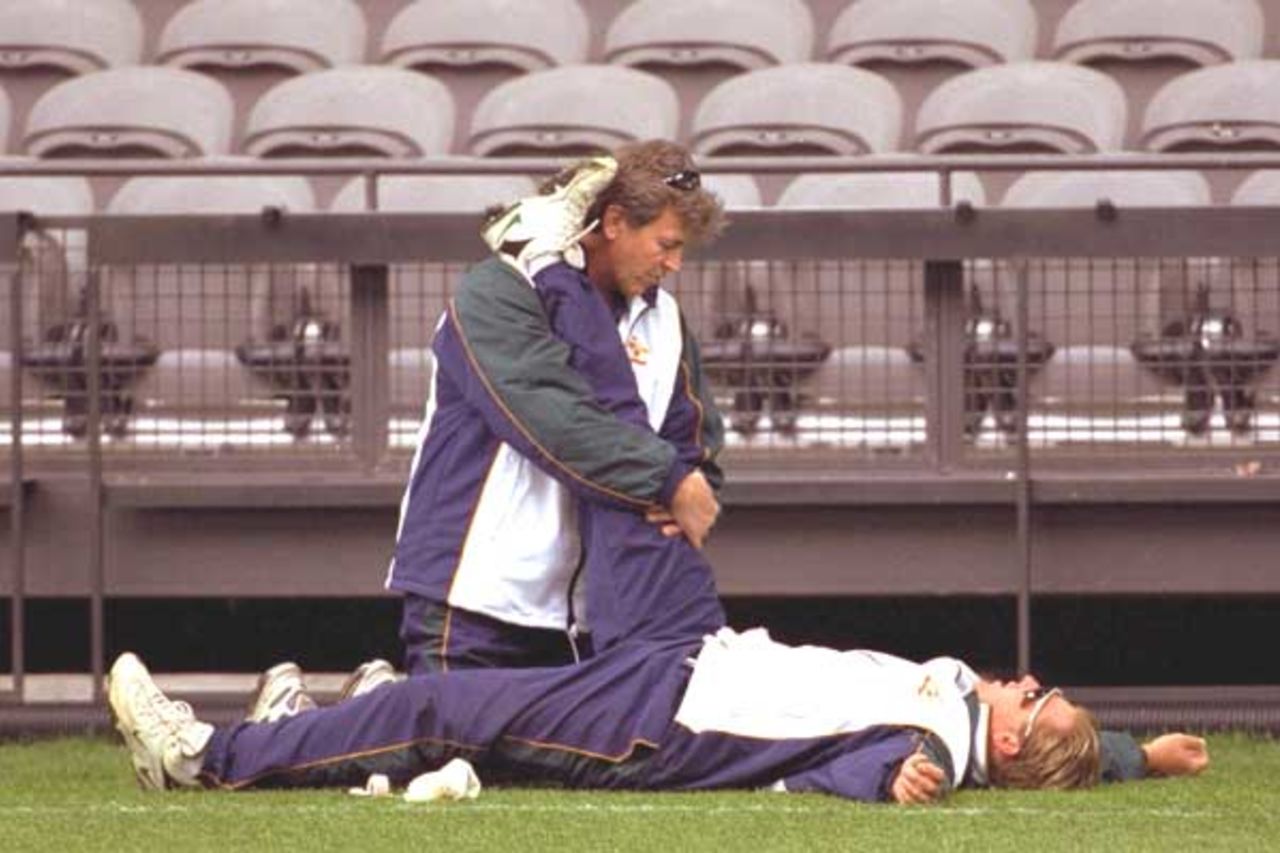 15 Aug 2000: Shane Warne of Australia is assisted by Errol Alcott on Colonial Stadium, venue for the Super Challenge 2000 one day cricket series beginning Wednesday in Melbourne, Australia.