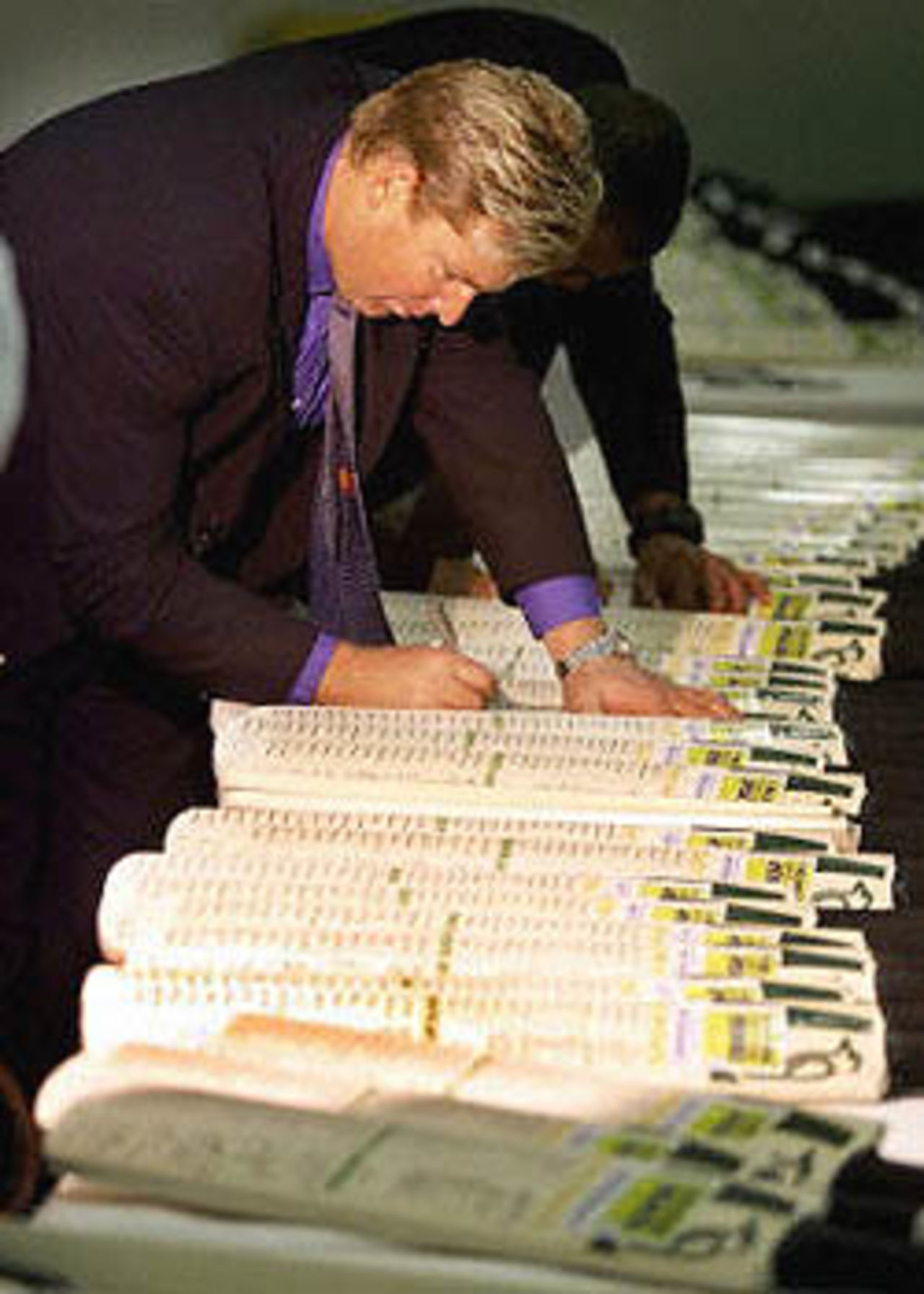 Australian spinner Shane Warne signs cricket bats as he prepares for his first game for Australia after losing the vice-captain's position when they meet South Africa under the closed roof of the Colonial Stadium in Melbourne, 14 August 2000. Australia and South Africa will create history when play the first one-day cricket matches to be played indoors when they meet on 16, 18 and 20 August. Super Challenge 2000.