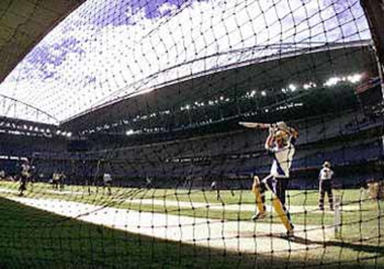 Australian batsman Michael Bevan (R) cuts a ball during a net session before Australia meet South Africa under the closed roof of the Colonial Stadium in Melbourne (15 August 2000). Australia and South Africa will create history when play the first one-day cricket match to be played indoors when they meet 16, 18 and 20 August. Super Challenge 2000.