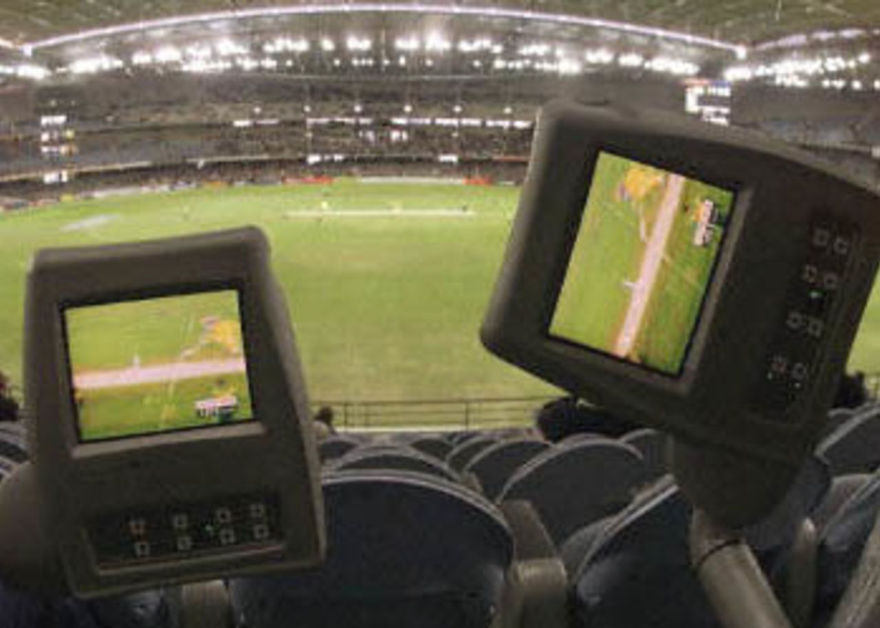 Television screens in the corporate seating section shows Australia's Adam Gilchrist being run out in the first one day cricket match in history to be played under a closed roof at the Colonial Stadium, as Australia takes on South Africa in Melbourne. Spectators can watch the action on the field or change channels for other sports or regular TV if the cricket is slow. Being played in the middle of winter in Melbourne, Australia is 109-3 in the 23rd over with captain Steve Waugh and Michael Bevan at the wicket. South Africa in Australia, 2000/01, 1st One-Day International, Australia v South Africa, Colonial Stadium, Melbourne, 16 August 2000.