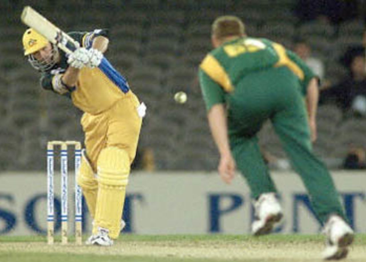 Australian captain Steve Waugh (L) slams a ball toward South African bowler Lance Klusener (R) on the way to scoring a century in the first one day cricket match in history to be played under a closed roof at the Colonial Stadium, as Australia takes on South Africa in Melbourne. Being played in the middle of winter in Melbourne, Australia scored 295-5 in their 50 overs with Waugh scoring 114 not out and Michael Bevan 106. South Africa in Australia, 2000/01, 1st One-Day International, Australia v South Africa, Colonial Stadium, Melbourne, 16 August 2000.