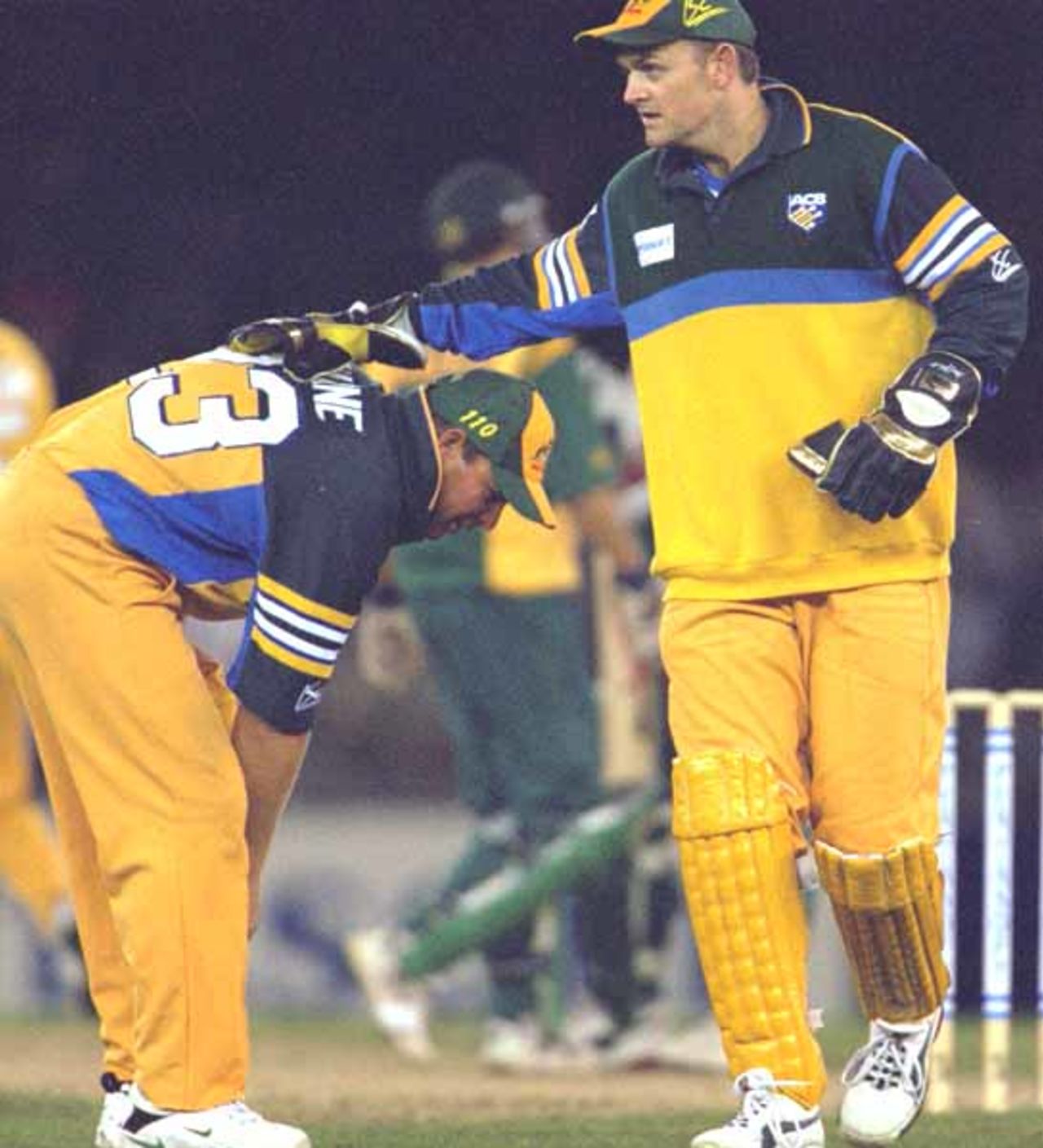 16 Aug 2000: Adam Gilchrist (right) of Australia encourages team mate Shane Warne, in the match between Australia and South Africa, in game one of the Super Challenge 2000, played at Colonial Stadium in Melbourne, Australia. This is the first game of cricket to be played indoors.