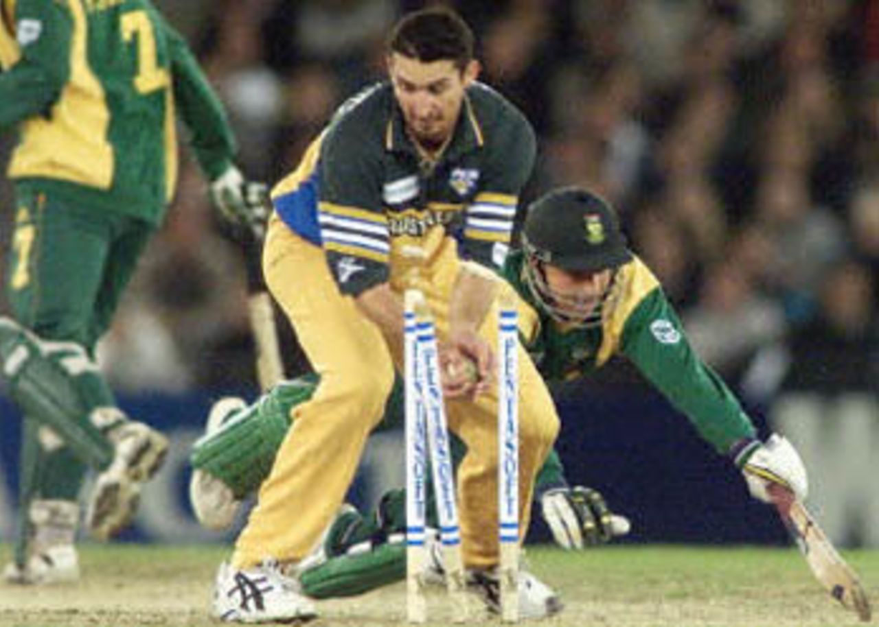 Jason Gillespie breaks the stumps to dismiss South African Boeta Dippenaar (R) their one day cricket match being played under a closed roof at the Colonial Stadium in Melbourne. Being played in the middle of winter in Melbourne, South Africa scored 206-7 from their 50 overs after being in deep trouble at 19-4. South Africa in Australia, 2000/01, 3rd One-Day International, Australia v South Africa, Colonial Stadium, Melbourne, 20 August 2000.
