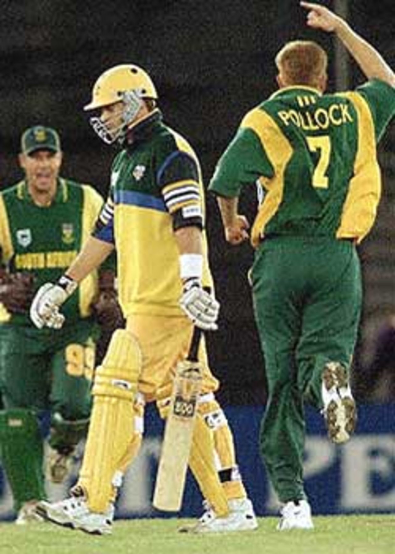 Australian batsman Mark Waugh (C) is given a send off by South African captain Shaun Pollock (R) and Andrew Hall (L) after been bowled by Pollock in their one-day cricket match being played under a closed roof at the Colonial Stadium in Melbourne. Being played in the middle of winter in Melbourne, South Africa scored 206-7 from their 50 overs d Australia is 171-6 in reply after 43 overs. South Africa in Australia, 2000/01, 3rd One-Day International, Australia v South Africa, Colonial Stadium, Melbourne, 20 August 2000.