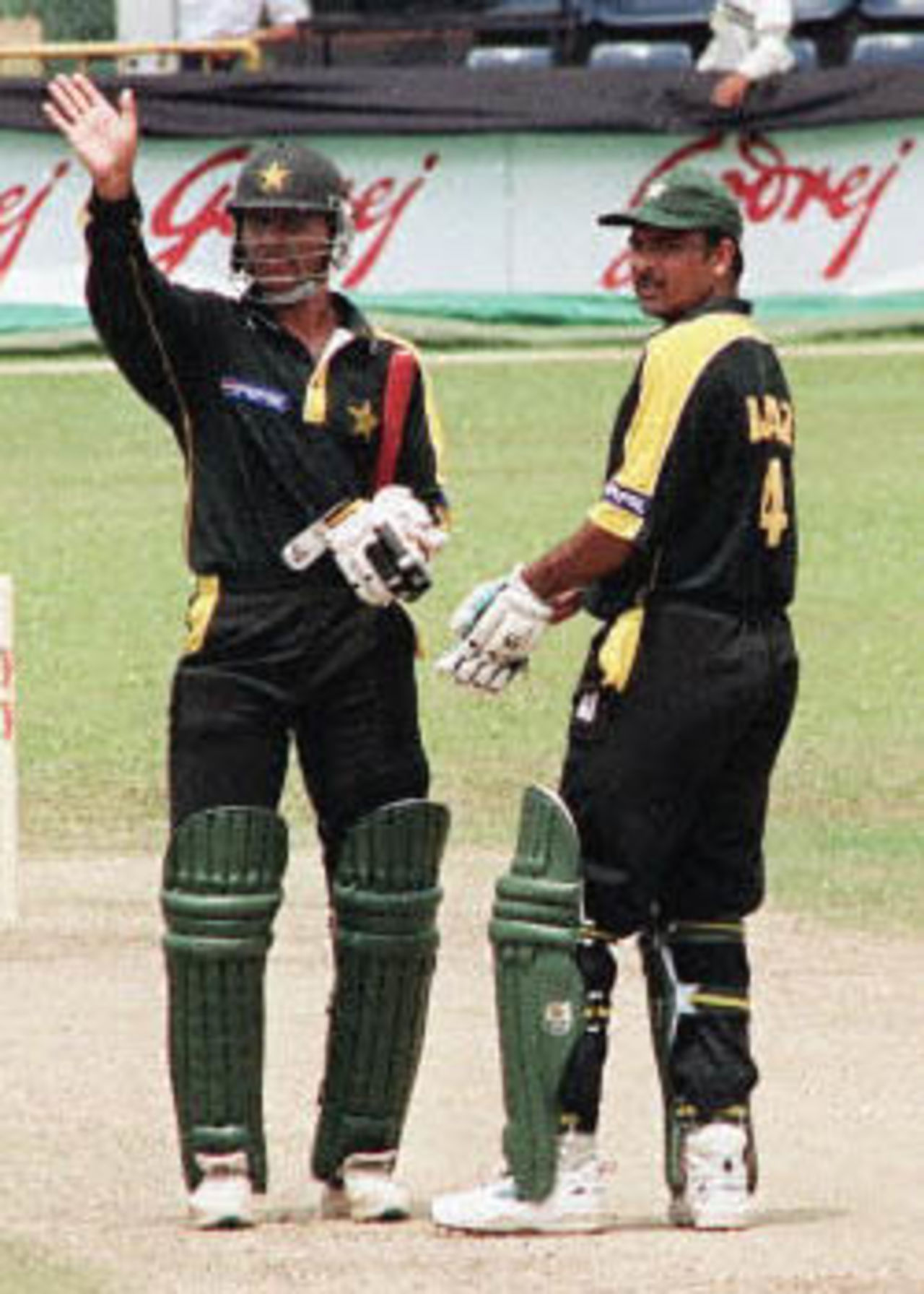 Pakistan's Abdur Razzaq (L) waves to the crowd as his teammate Ijaz Ahmed (R) watches during their match against South Africa at the Singapore Challenge 2000. Pakistan made 227 for nine off their 50 overs against South Africa. Godrej Singapore Challenge, 2000/01, 2nd Match, Pakistan v South Africa, Kallang Ground, Singapore 23 August 2000.