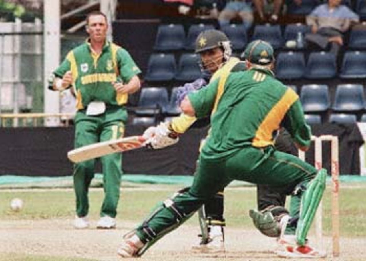 Pakistan's Abdur Razzaq (C) looks back after batting against South Africa during the Singapore Challenge 2000 as South Africa's Nicky Boje (L) looks on. Pakistan made 227 for nine off their 50 overs against South Africa. Player at right is unidentified. Godrej Singapore Challenge, 2000/01, 2nd Match, Pakistan v South Africa, Kallang Ground, Singapore 23 August 2000.