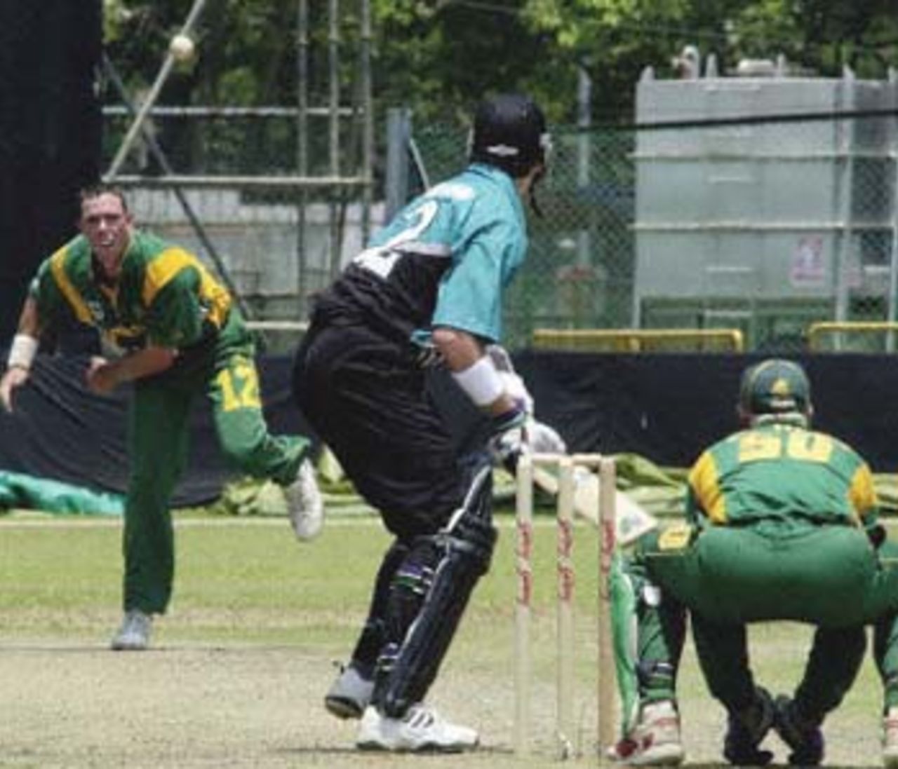 South African bowler, Nicky Boje (L), bowls to New Zealand batsman, Paul Wiseman (C), as South African wicketkeeper, Shaun Pollock, appears ready for a catch, during the Singapore Challenge 2000 cricket triangular in Singapore. South Africa made their way into a prime position as they dismissed New Zealand for 158 in the deciting match to find the second finalist of the tournament. Godrej Singapore Challenge, 2000/01, 3rd Match, New Zealand v South Africa, Kallang Ground, Singapore 25 August 2000.