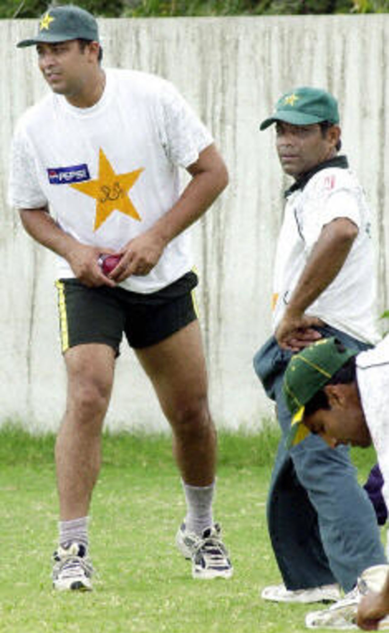 Pakistan cricketer Inzamam-ul-Haq (L) prepares to throw a ball as team captain Rashid Latif (R) looks on during a net training session at the National Stadium in Karachi, 18 August 2003. The team is preparing for a test match series against Bangladesh which will commence on 20 August.