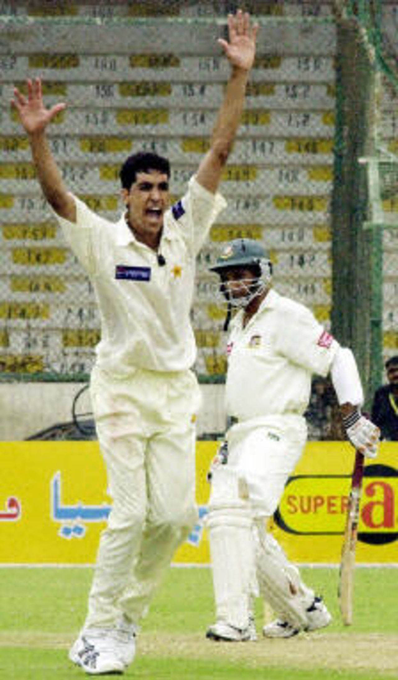 Habibul Bashar (R) looks on as Umar Gul (L) unsuccessfuly appeals for an LBW decission during the first day of the first Test match at Karachi National Stadium, 20 August 2003.