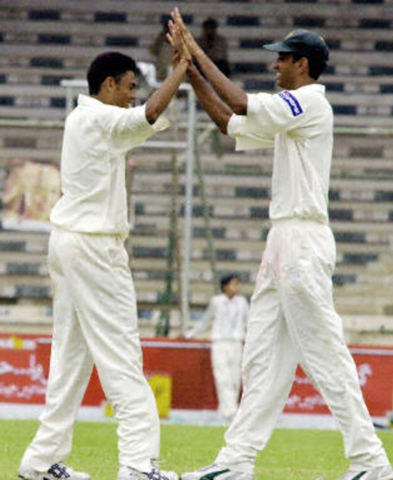 Danish Kaneria (L) celebrates with teammate Shabbir Ahmed (R) after dismissing Bangaldeshi batsman Alok Kapali, first day of the first Test at National Stadium in Karachi, 20 August 2003.