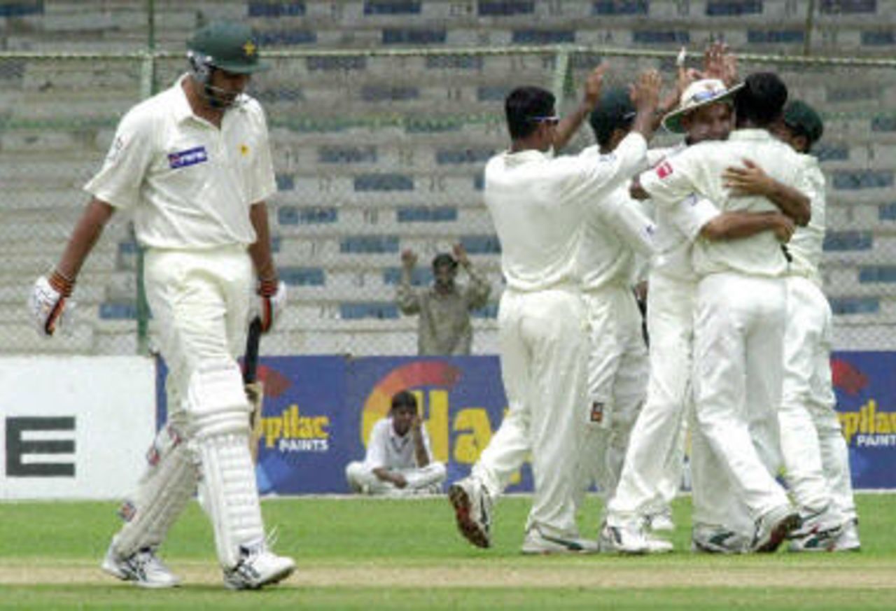 Inzamam-ul-Haq (L) leaves the field for a duck as Banglaeshi cricketers celebrate during the second day of the first Test, 21 August 2003.