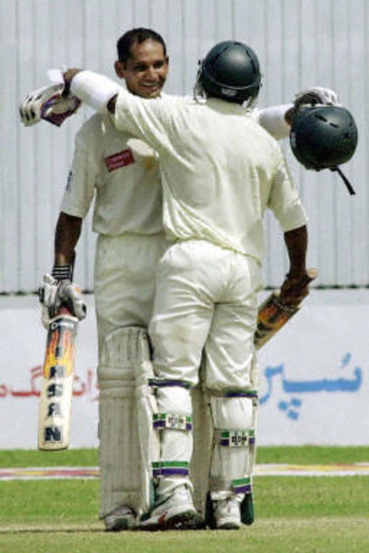 Habibul Bashar (L) is congratulated by Rajin Saleh (R) after compeleting his century during the fourth day of the first Test match between Pakistan and Bangladesh in Karachi, 23 August 2003.