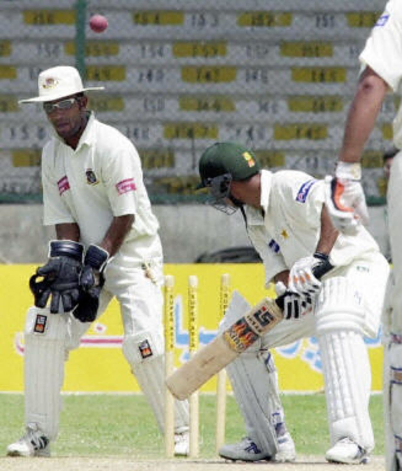 Yasir Hameed (C) is bowled as Khaled Mashud (L) looks on after hitting 105 on the last day play of the first Test match between Pakistan and Bangladesh in Karachi, 24 August 2003.
