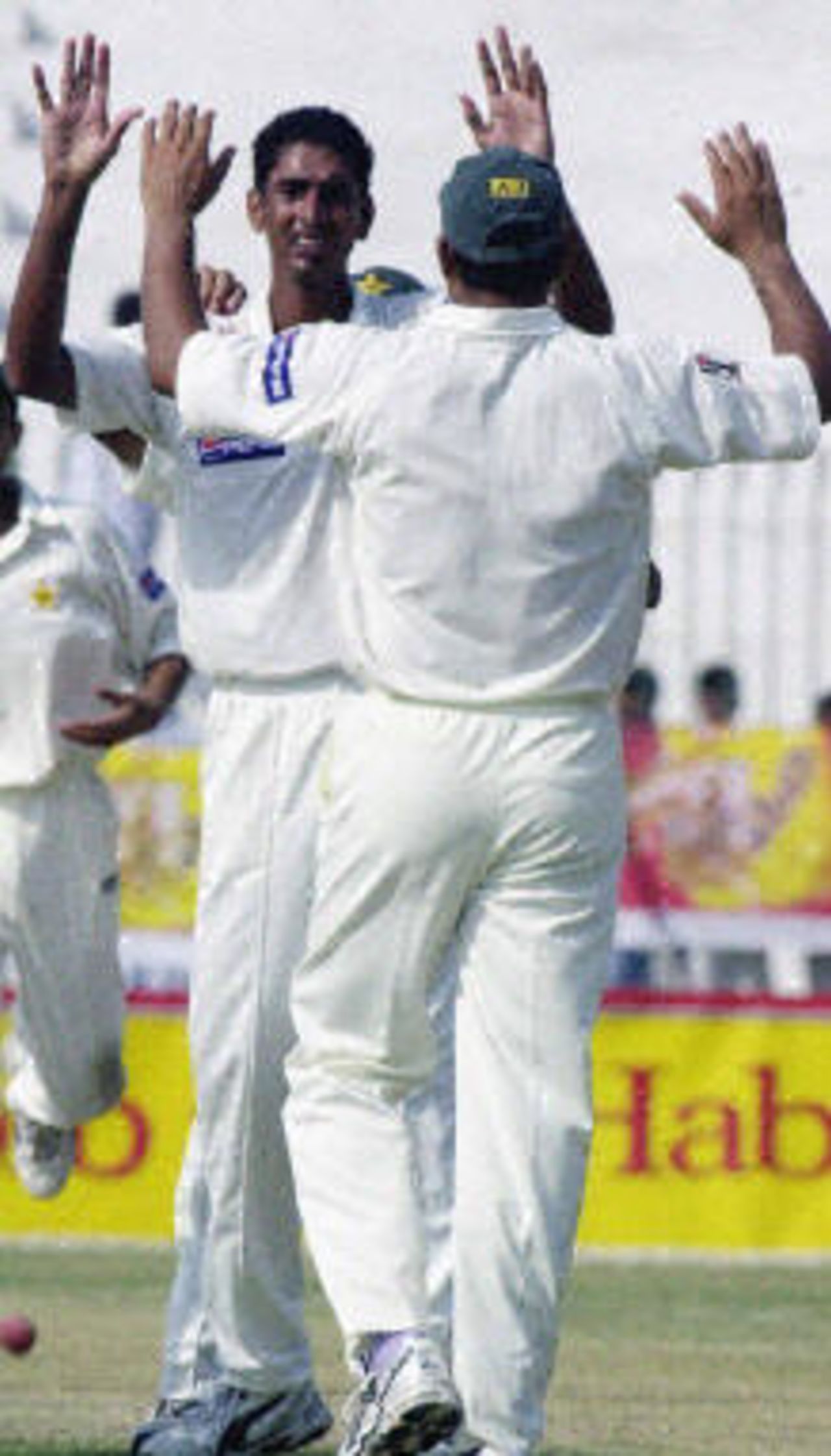 Shabbir Ahmed (L) celebrates Habibul Bashar's wicket with a teammate during the first day of the second Test between Pakistan and Bangladesh in Peshawar, 27 August 2003.