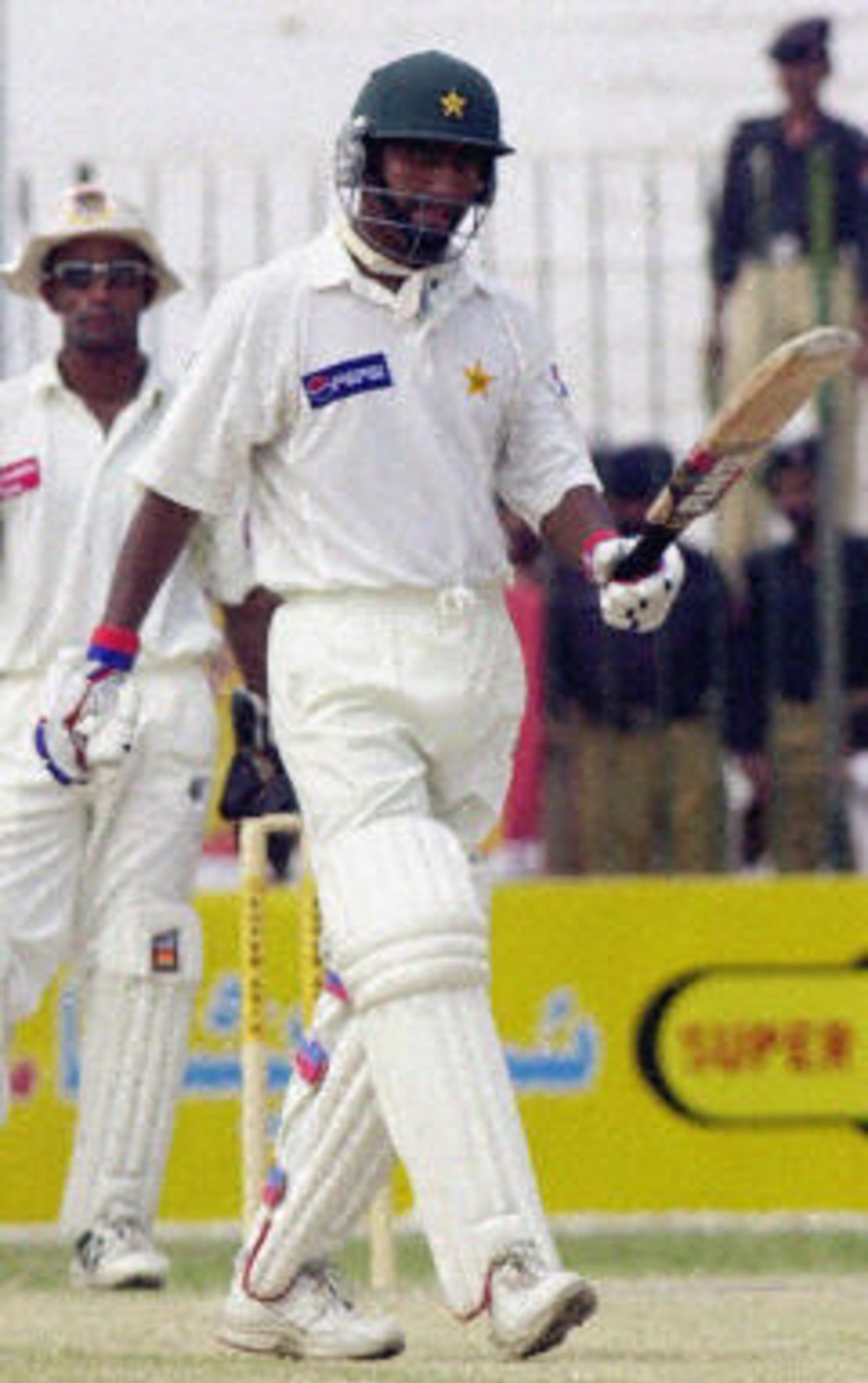 Yousuf Youhana (R) raises his bat to acknowledge cheers after scoring a half-century during the third day of the second Test between Pakistan and Bangladesh in Peshawar, 29 August 2003.