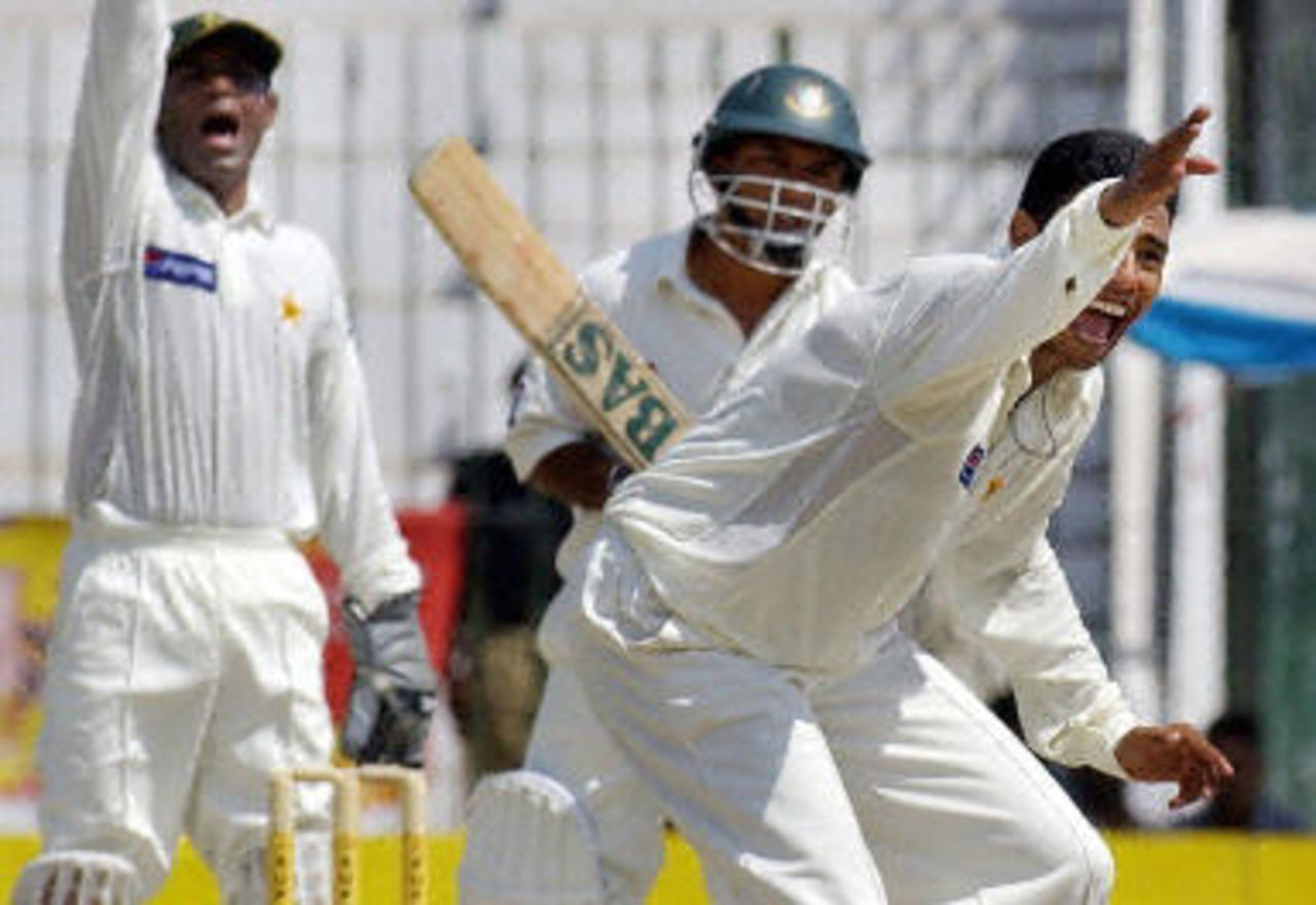 Danish Kaneria (R) and Rashid Latif (L) successfuly appeal for an LBW decision against Khaled Mahmud during the fourth day of the second Test between Pakistan and Bangladesh in Peshawar, 30 August 2003.