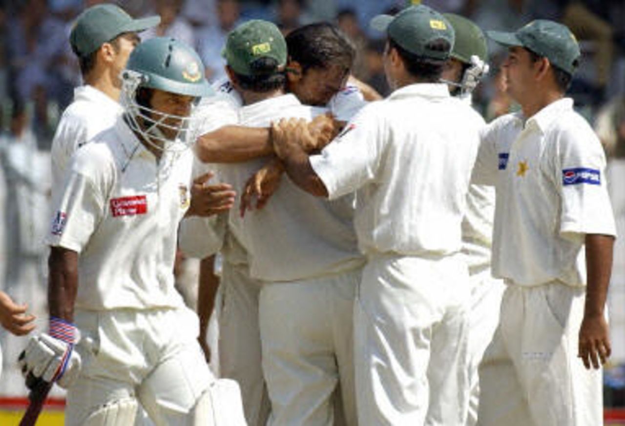 Shoaib Akhtar (C) embraced by captain Rashid Latif after taking his 100th Test wicket during the fourth day of the second Test between Pakistan and Bangladesh in Peshawar, 30 August 2003.