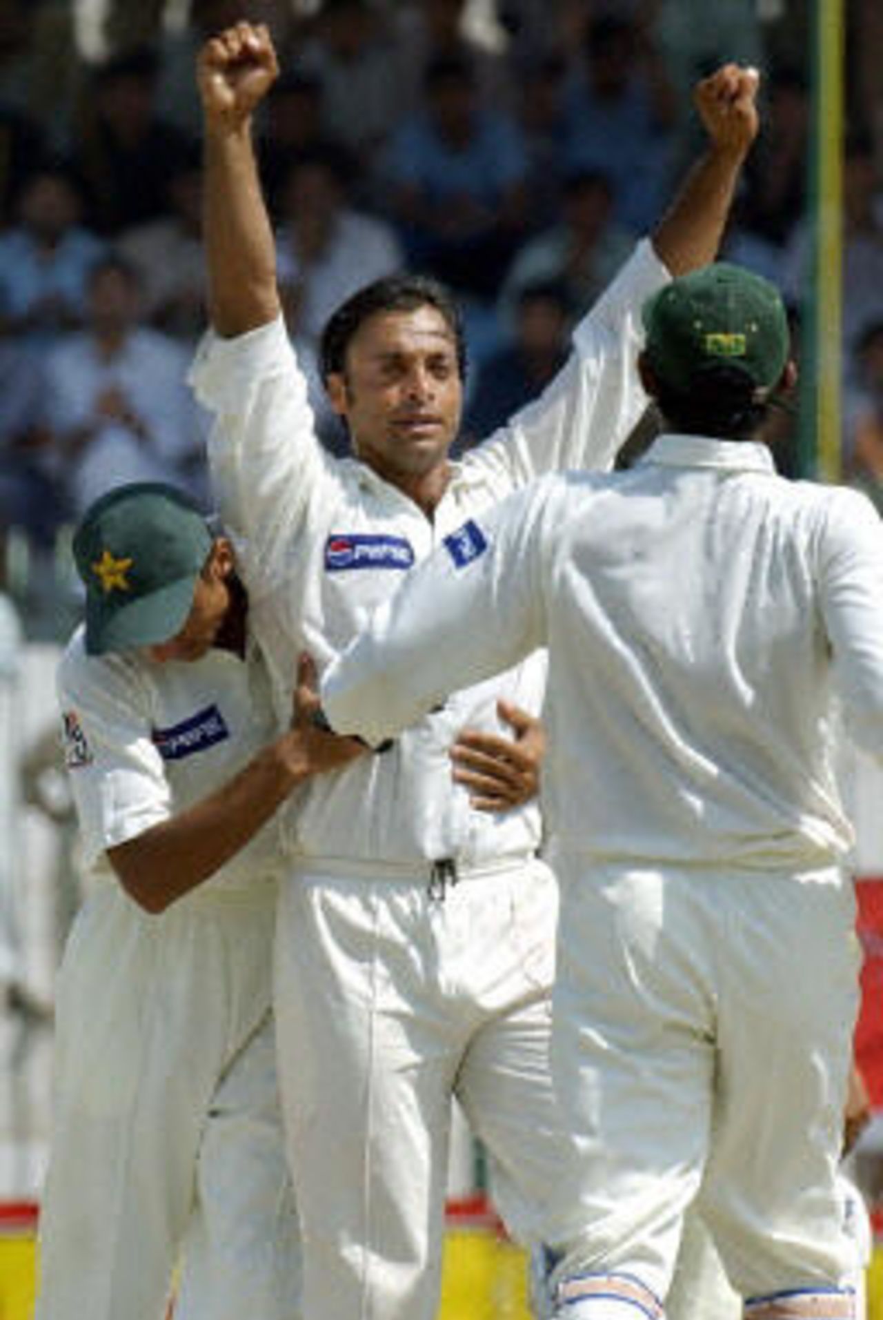 Shoaib Akhtar (C) celebrates taking 100 Test wickets in his 27th Test after dismissing Rajin Saleh (not in the picture) with his teammates during the fourth day of the second Test between Pakistan and Bangladesh in Peshawar, 30 August 2003.