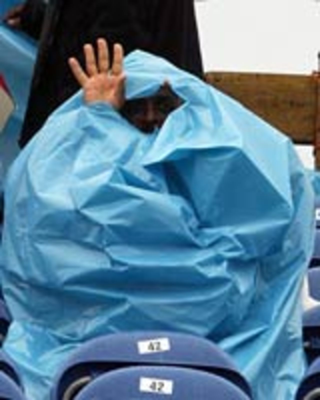 A fan takes cover from the rain at Amstelveen, India v Australia, 2nd match, Videocon Cup, Amstelveen, August 23, 2004